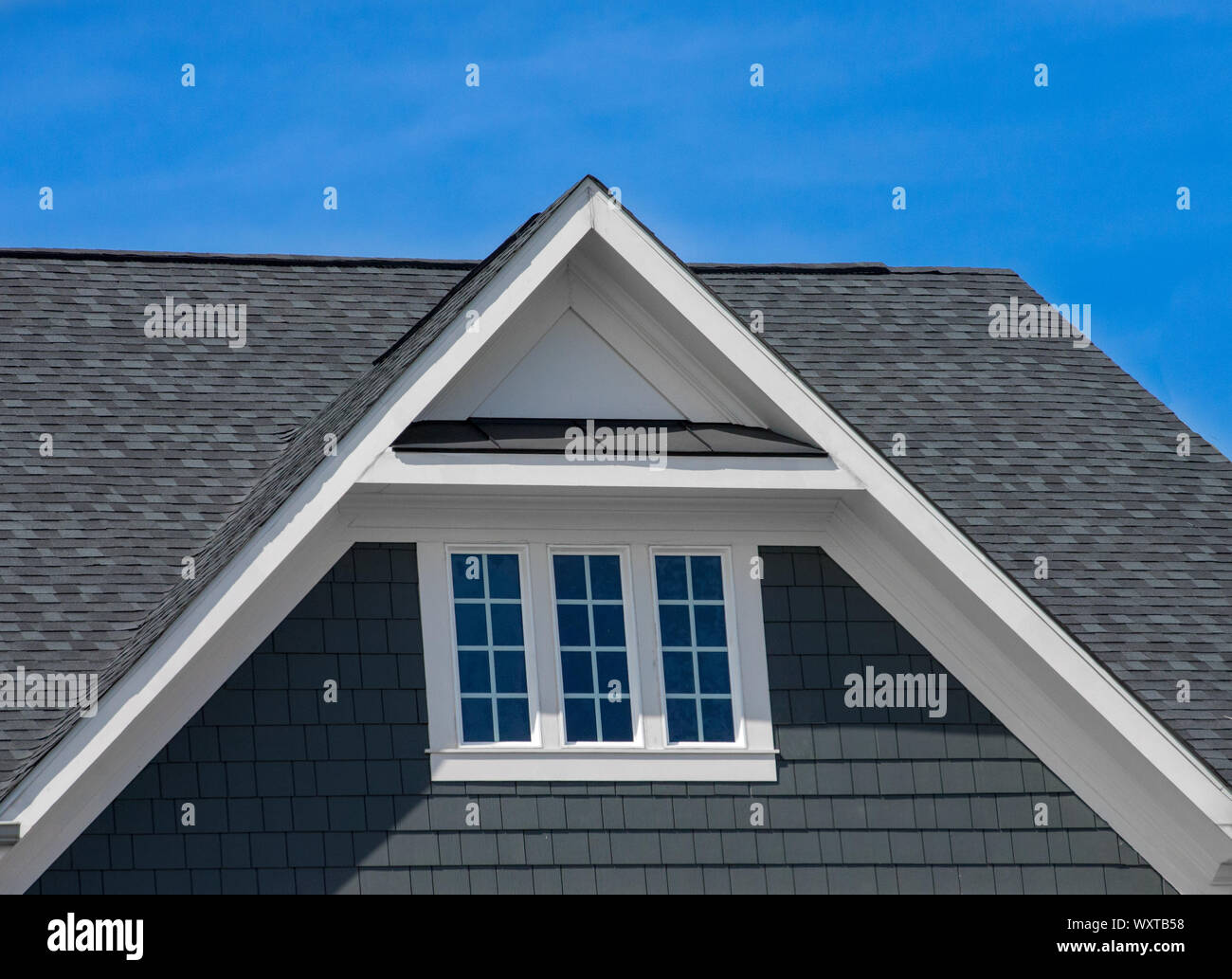 Di plastica o di legno tetto bianco decorazione gable, corbel, feritoia su una nuova costruzione di lusso singolo americano casa di famiglia nella costa orientale USA con blue s Foto Stock
