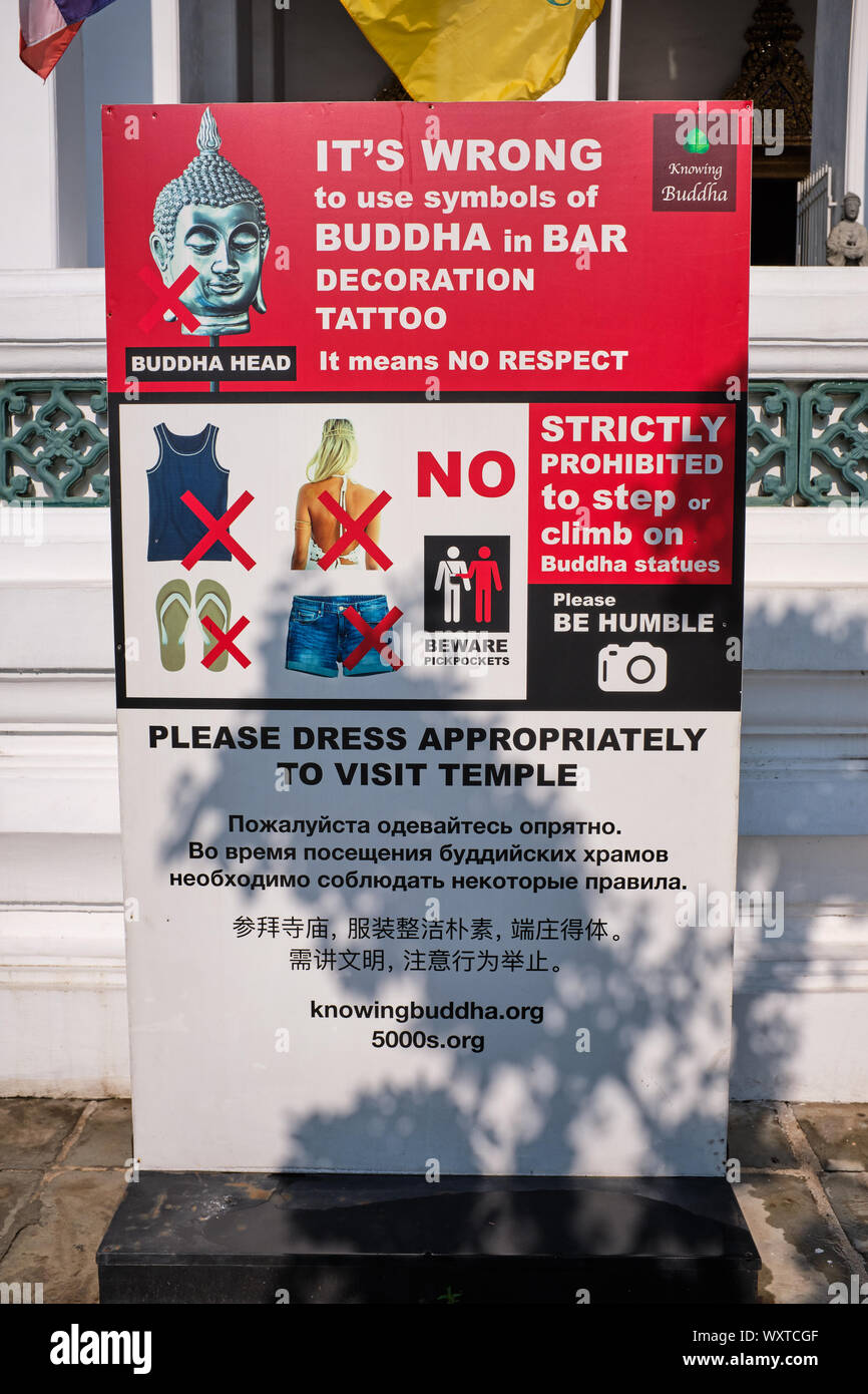 Un cartello del Parco di Wat Suthat di Bangkok, Tailandia, consigliare i visitatori stranieri sul comportamento corretto e abiti durante le visite del tempio Foto Stock