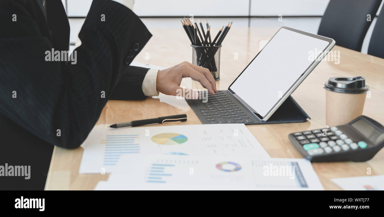 Vista ravvicinata del giovane commercialista riassumendo l attuale stato finanziario durante l'utilizzo di tablet Foto Stock