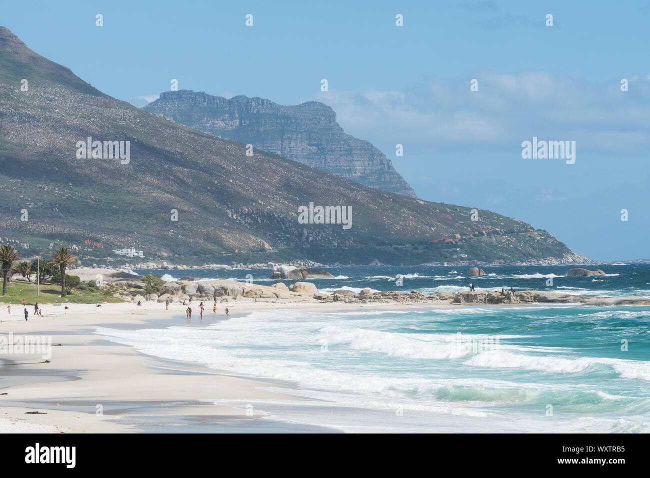 Camps Bay paesaggio e paesaggi marini di sabbia bianca spiaggia bandiera blu e acque turchesi dell'oceano Atlantico con beachgoers di Città del Capo in Sud Africa Foto Stock