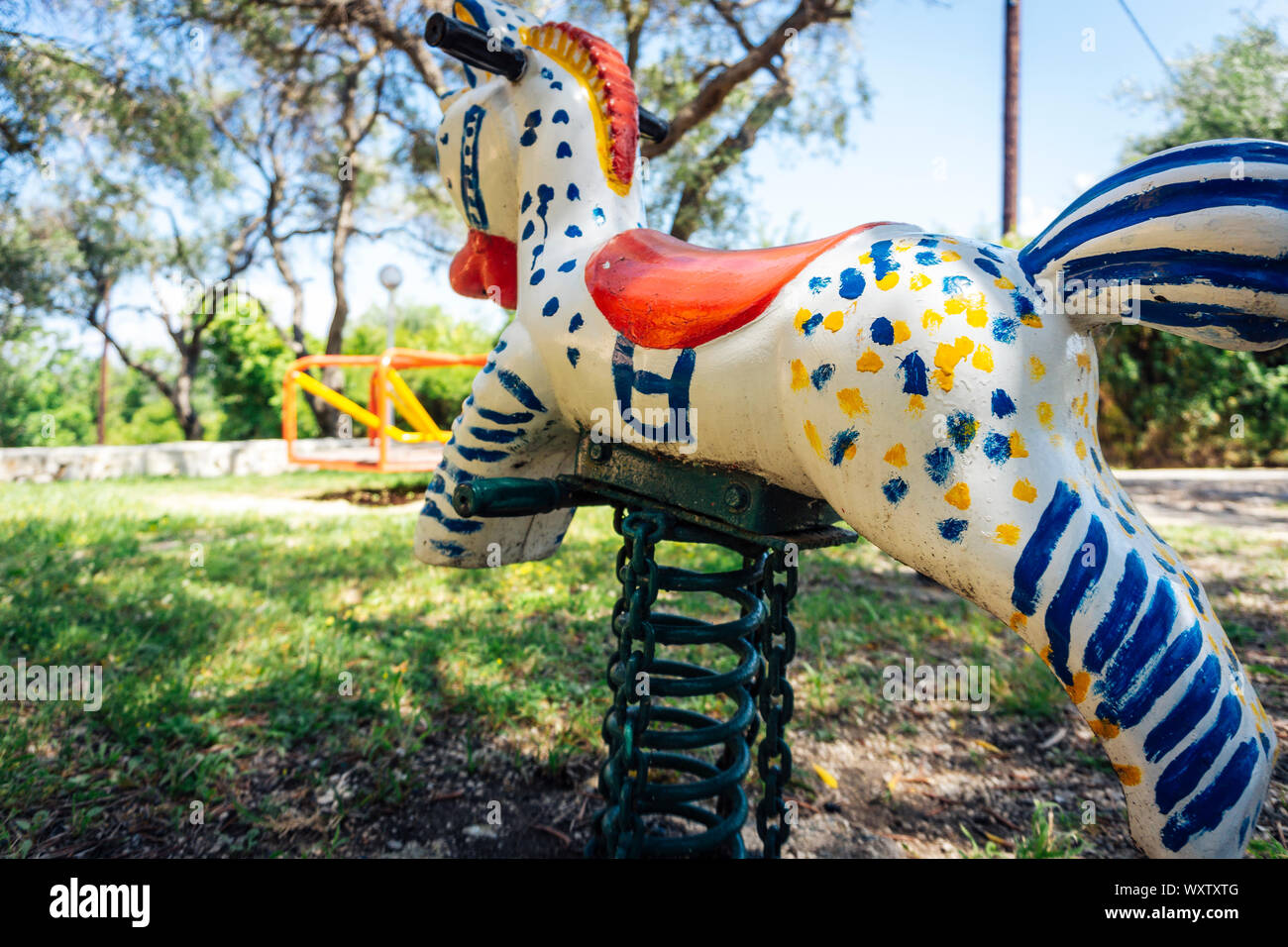 Close-up di un vecchio dipinte a mano e parco giochi cavallo a dondolo con spirale Foto Stock