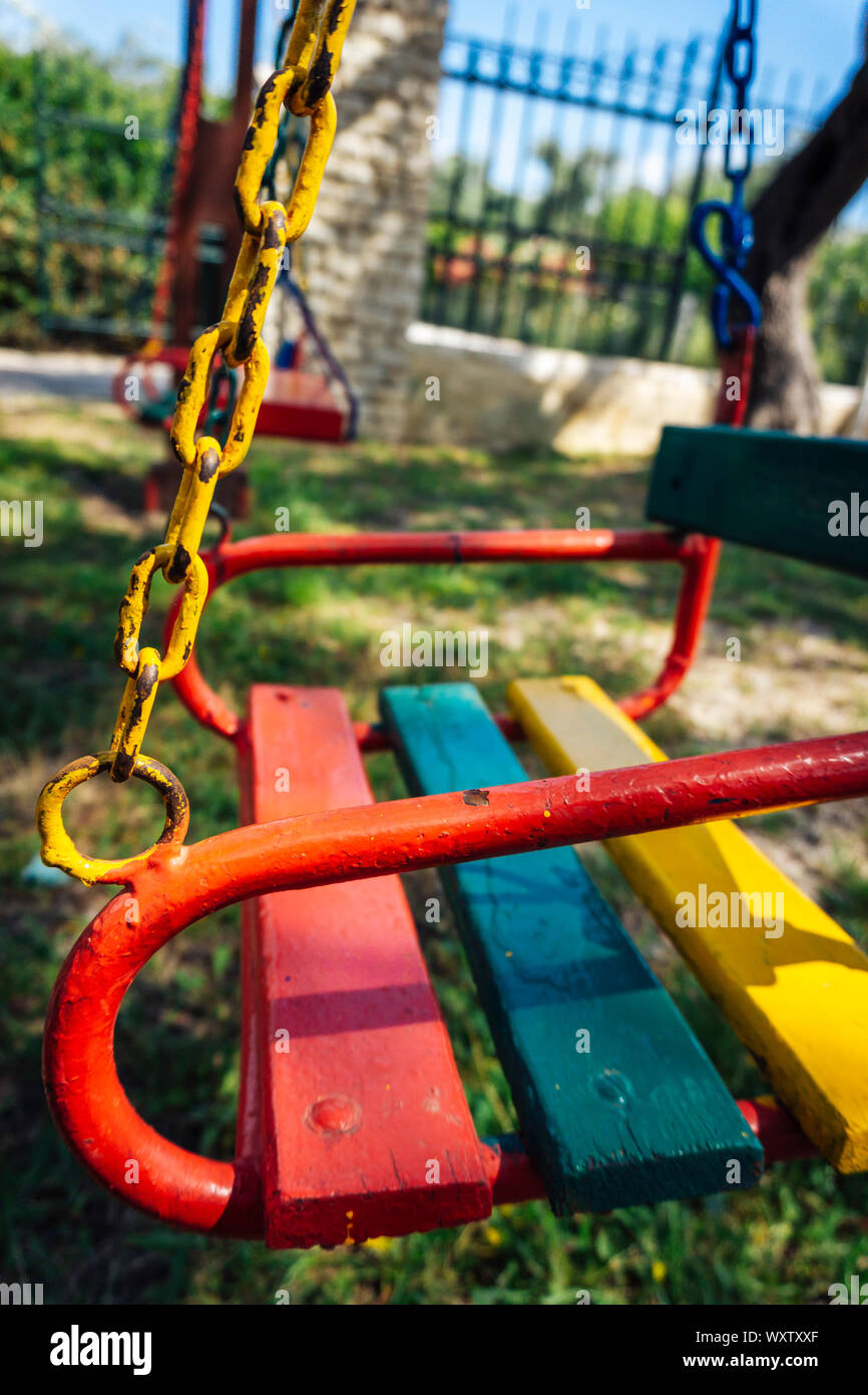 Primo piano della sede di un bambino swing con la vernice scheggiature sulla catena titolare Foto Stock
