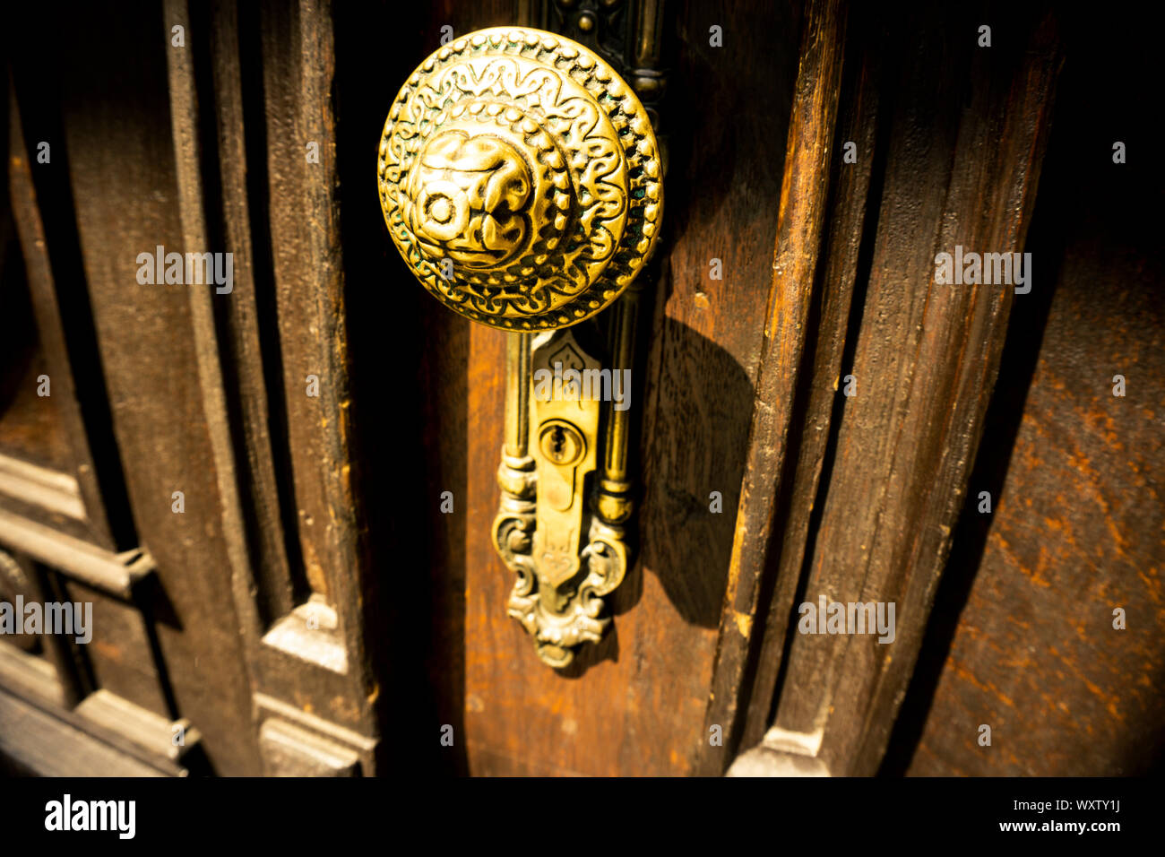 Soft focus, offuscata del vecchio scuro golden door la manopola sulla porta di legno, vista ravvicinata, un po' di spazio per il testo aggiuntivo Foto Stock