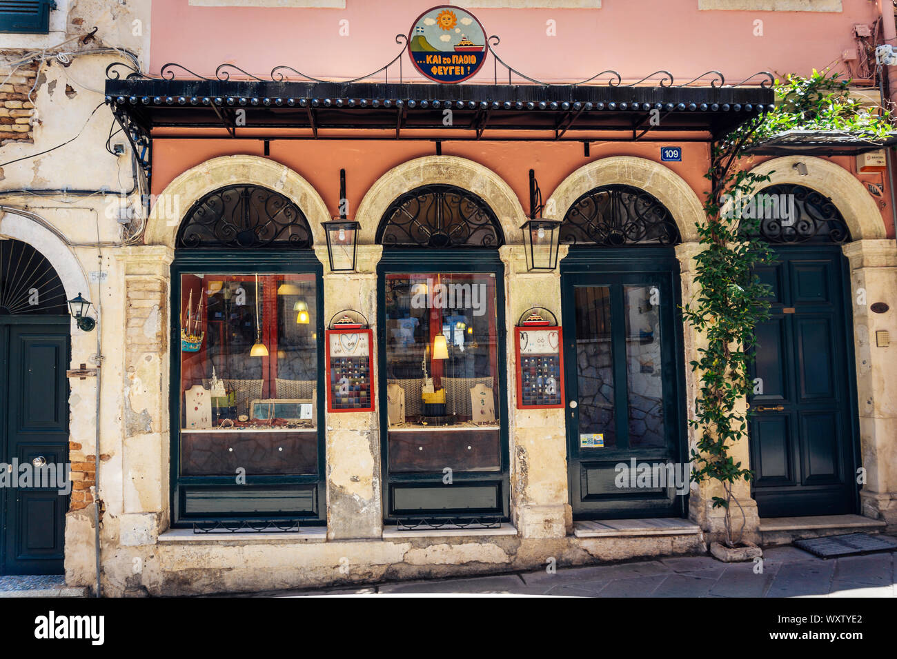 Corfù, Grecia - Giugno 06, 2018: negozio finestra Selezioni di gioielli facciata con un vitigno selvatico pianta e un bel segno negozio in Grecia - isole di Corfu - Corfu Foto Stock