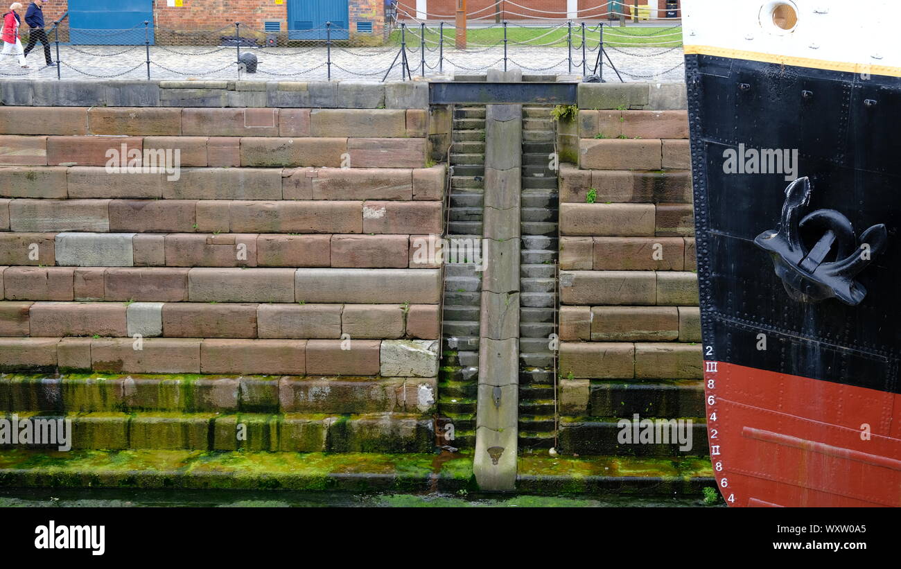 Il muschio cresce su scale di calcestruzzo nel bacino di carenaggio di Belfast Foto Stock