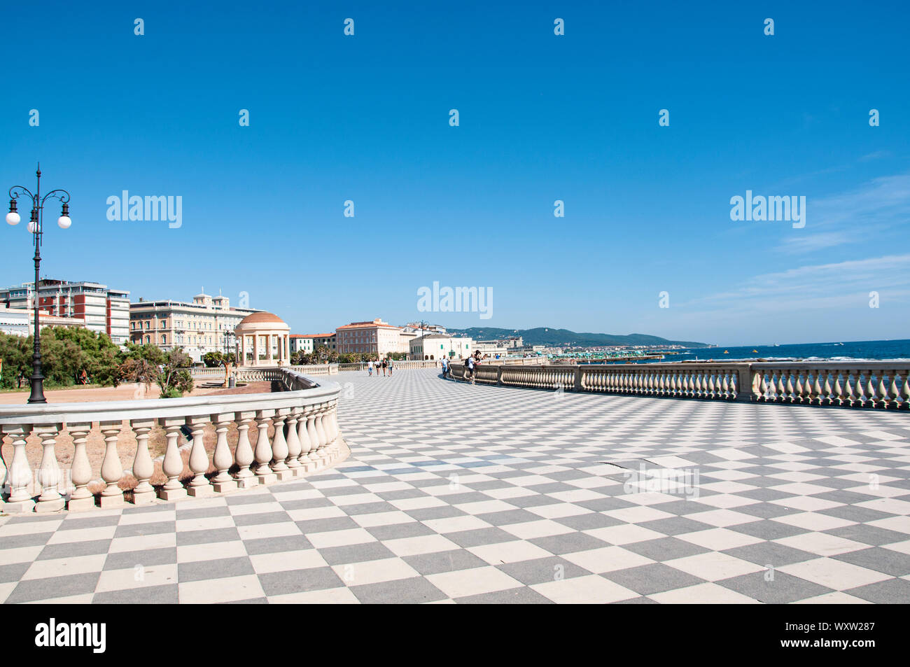 Basso angolo vista della pavimentazione a scacchiera sul lungomare della Terrazza Mascagni a Livorno, Toscana, Italia come esso si incurva lungo il lungomare su un soleggiato Foto Stock