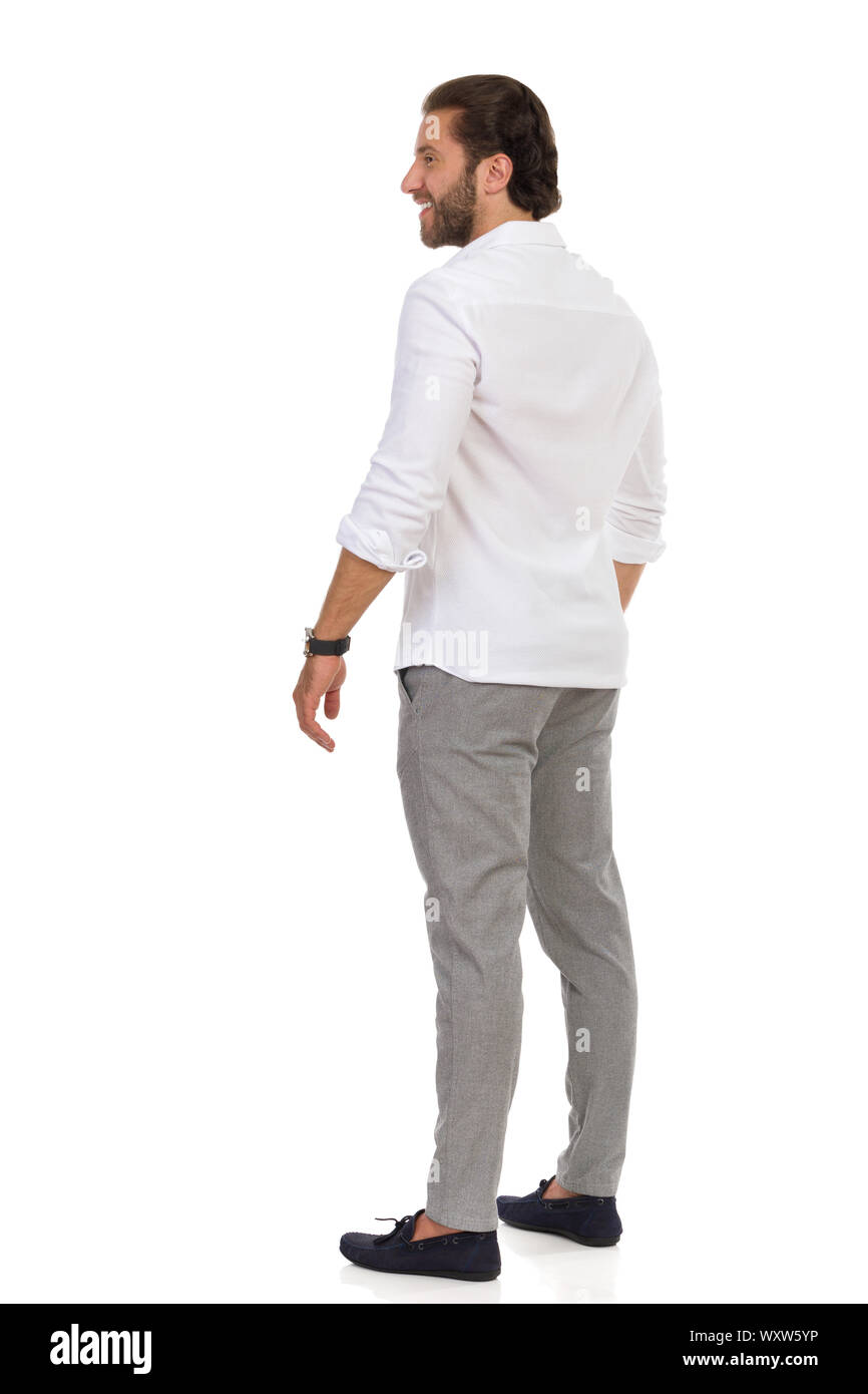 Vista lato posteriore di elegante uomo bello in mocassini, grigio pantaloni  e camicia bianca, in piedi e guardando lontano. Lunghezza completa studio  shot isolato su whi Foto stock - Alamy