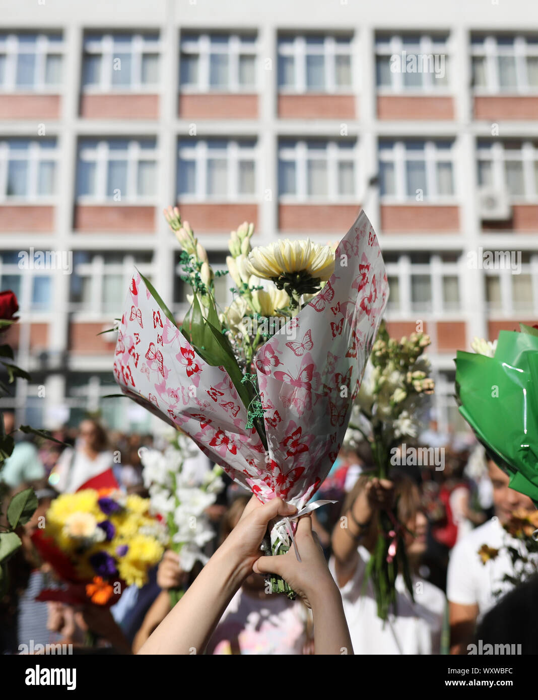 I bambini tenere i fiori nel loro primo giorno di scuola Foto Stock