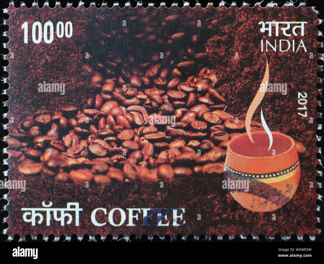 Chicchi di caffè e la coppa sulla indian francobollo Foto Stock