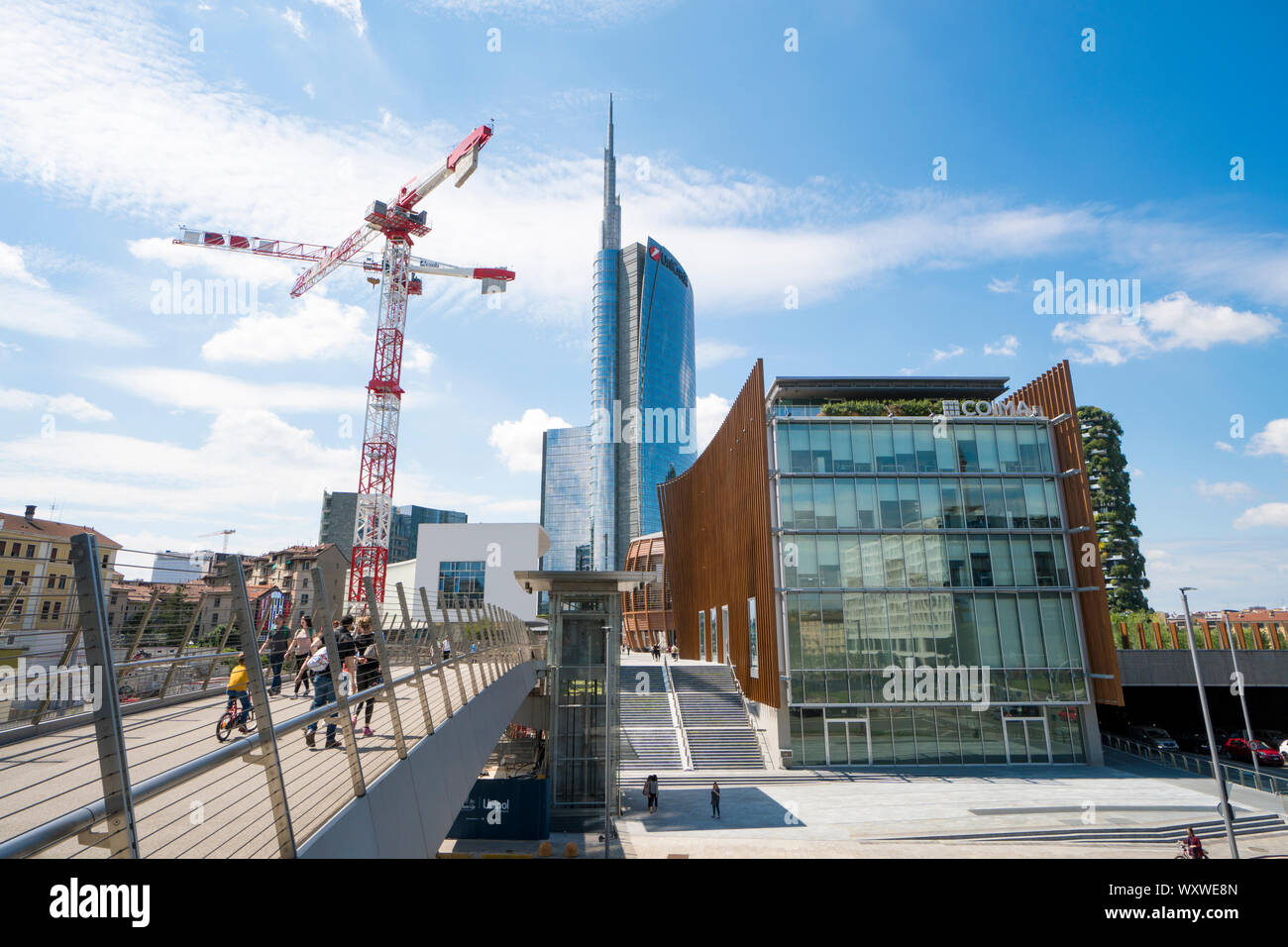 Milano, Italia: ponte pedonale a Porta Nuova Varesine distretto con il cantiere per la costruzione di gru per il nuovo grattacielo chiamato nido verticale Foto Stock