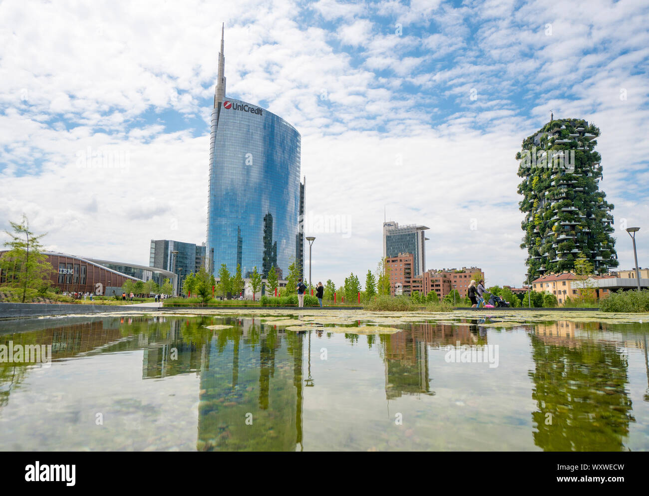 Milano, Italia: il laghetto del nuovo parco pubblico denominato "Biblioteca degli alberi" (Libreria ad albero), sullo sfondo il "Bosco Verticale" degli edifici Foto Stock