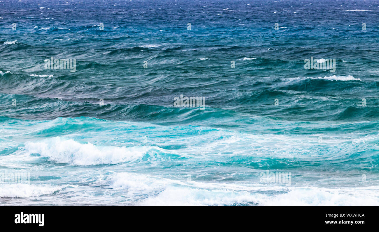 Blue Riva tempestoso acqua del mare Mediterraneo con onde, panoramica foto di sfondo preso dalla costa dell'isola di Cipro Foto Stock