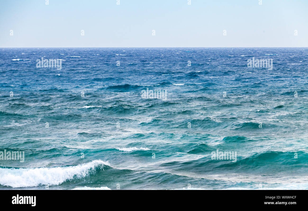 Stormy shore acqua del mare Mediterraneo. Grandi onde sotto il cielo blu, sfondo naturale foto scattata dalla costa dell'isola di Cipro Foto Stock