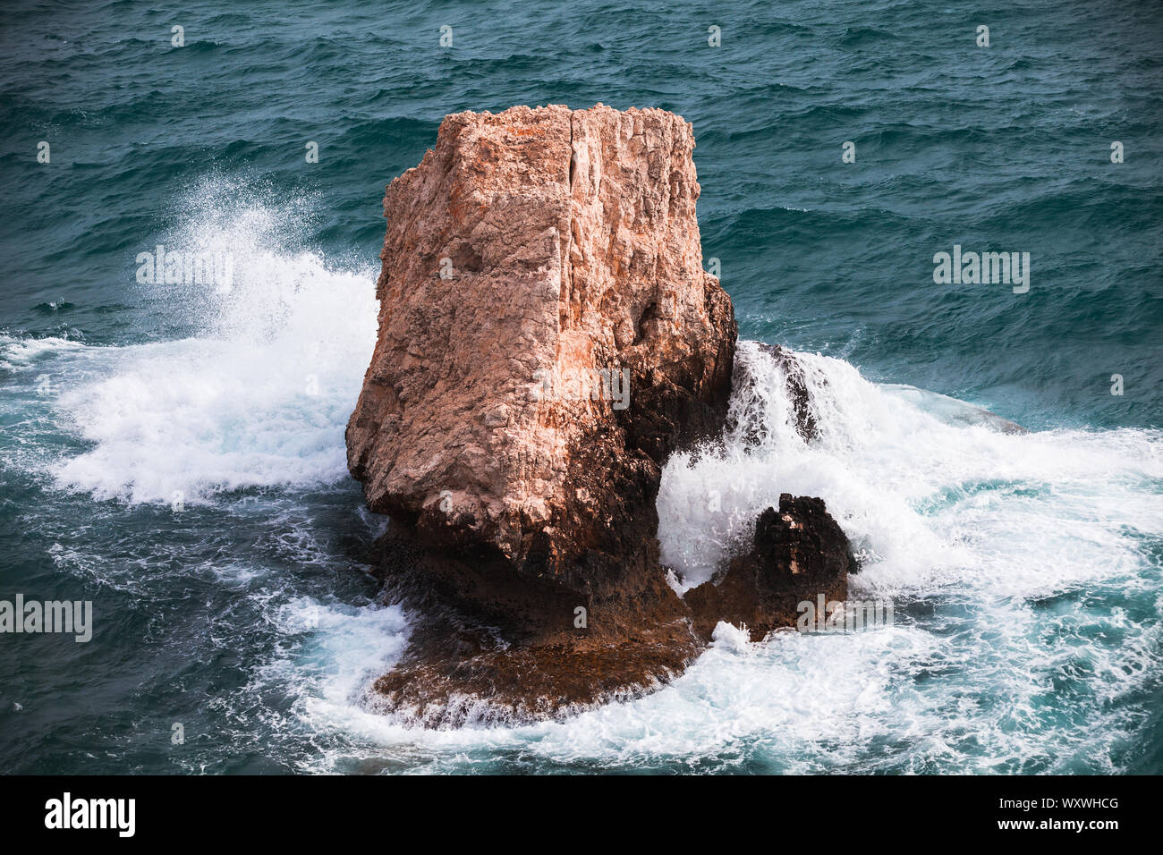 Costiera isolotto roccioso con spruzzi delle onde. Mare Mediterraneo, Cipro Foto Stock