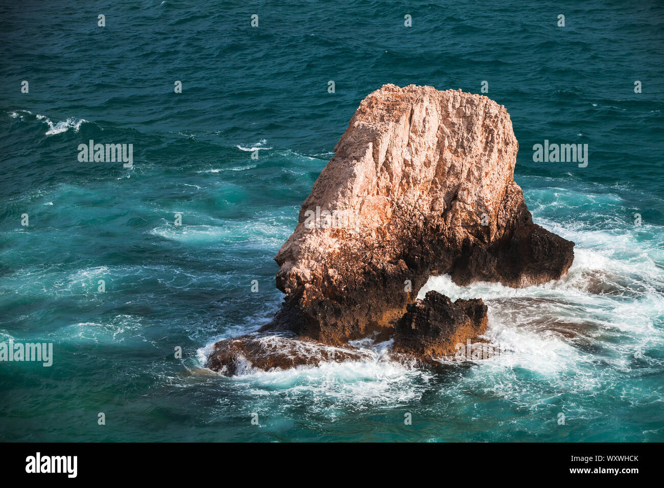 Isolotto roccioso con spruzzi delle onde. Mare Mediterraneo, Cipro Foto Stock