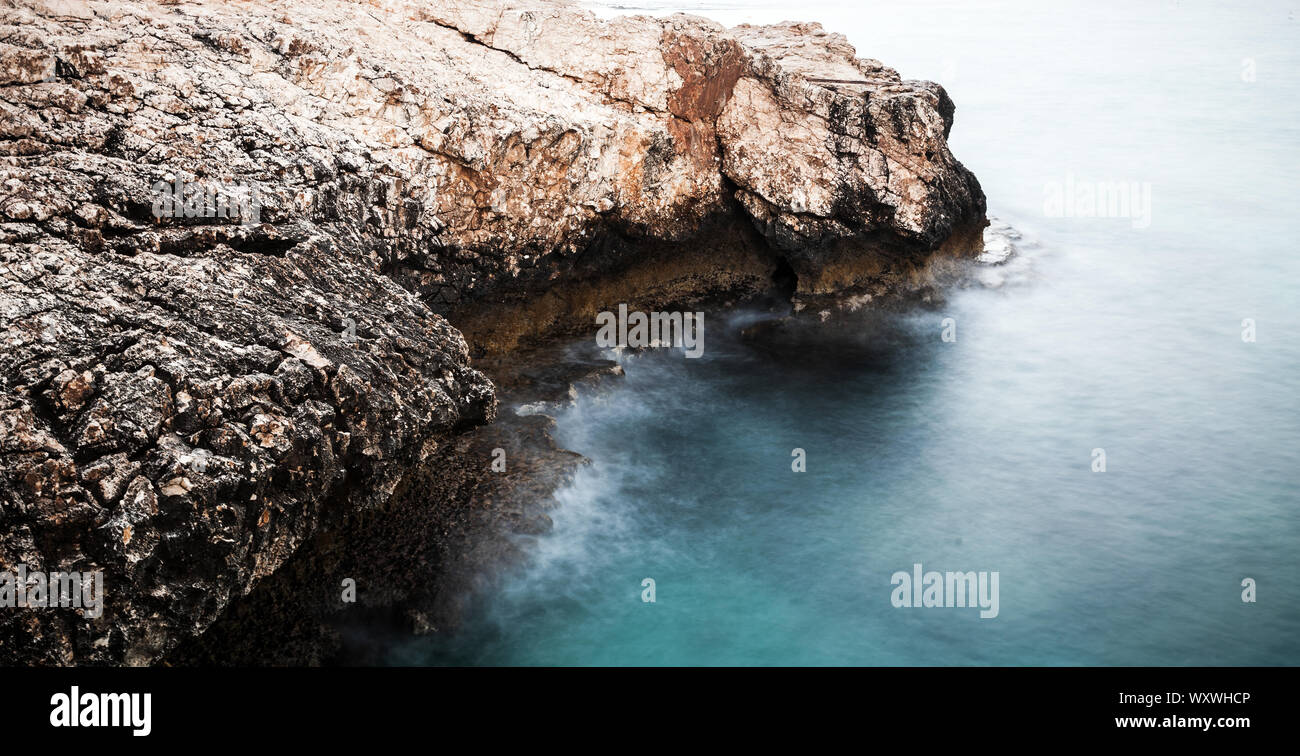 Mare Mediterraneo, paesaggio con rocce costiere. Lunga esposizione con foto sfocate naturale effetto dell'acqua. Ayia Napa, isola di Cipro Foto Stock