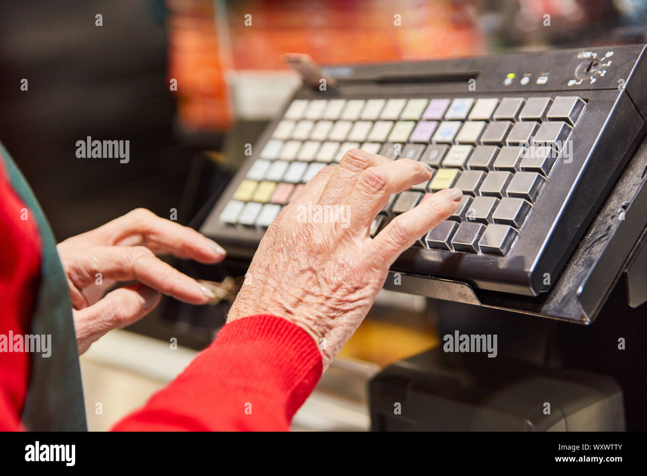 Le mani di un cassiere la digitazione sulla tastiera del registratore di cassa Foto Stock
