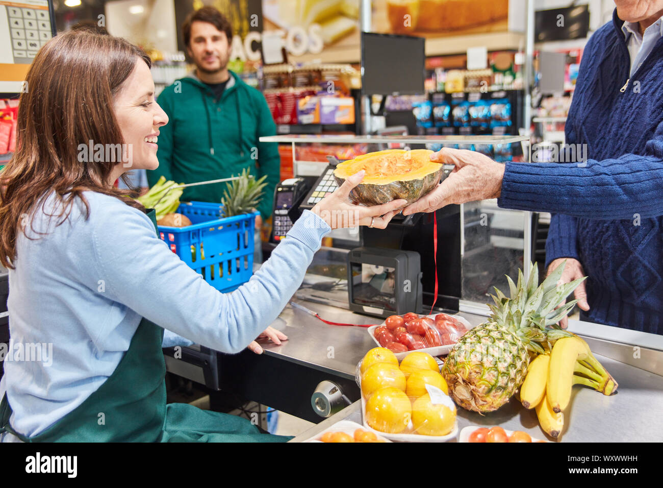 Giovane donna come cassiere o assistente alla cassa di un supermercato o negozio di sconto Foto Stock