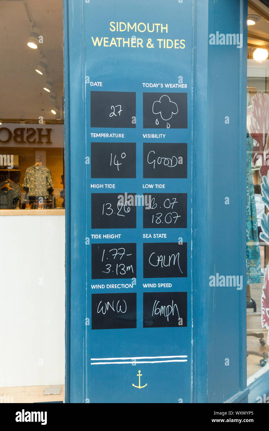 Meteo e informazioni sulle maree visualizzata su una lavagna al di fuori di un high street shop a Sidmouth, nel Devon. Regno Unito (110) Foto Stock