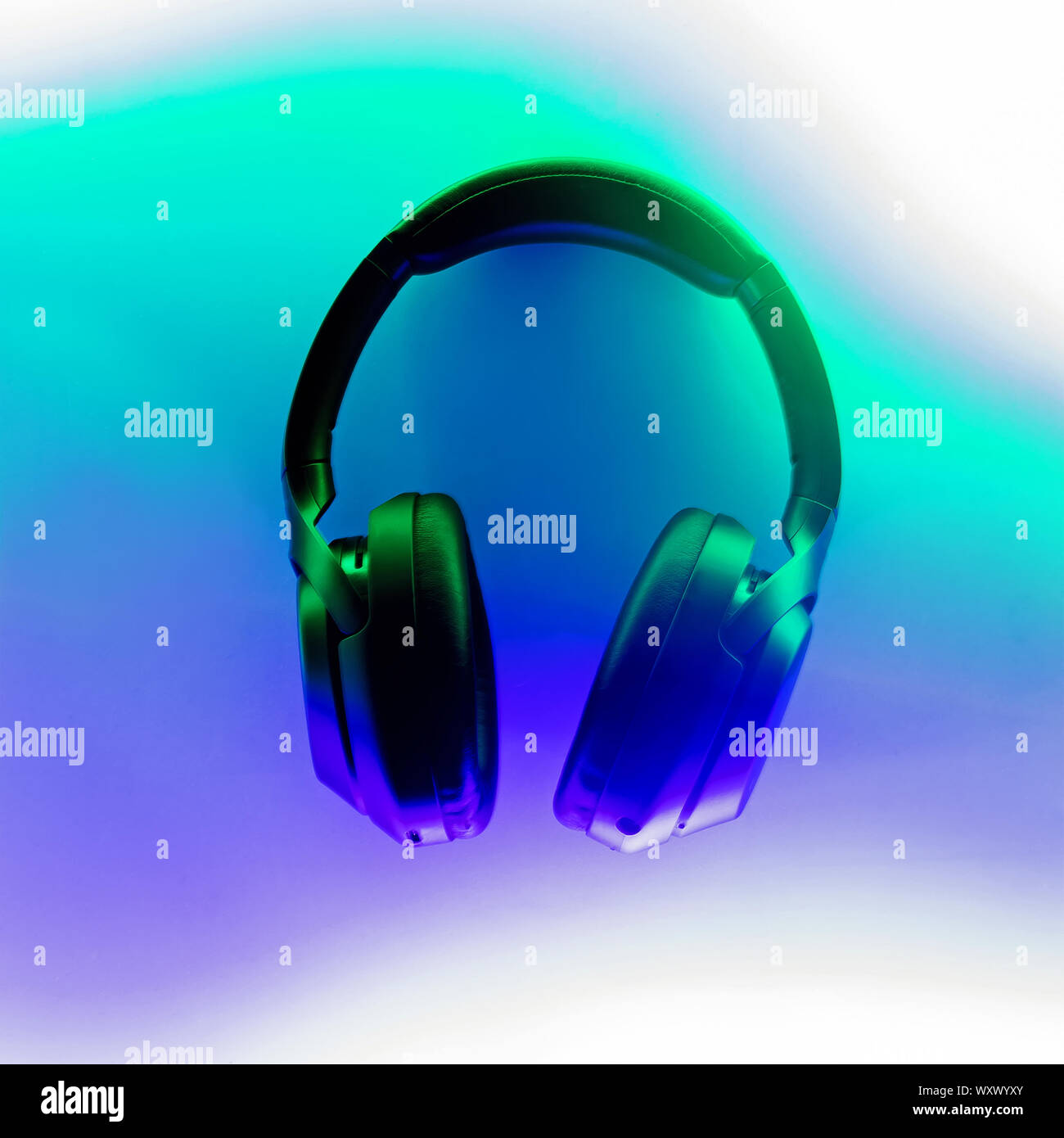 Cuffie wireless illuminato con una luce al neon di verde e viola i colori, vista dall'alto Foto Stock