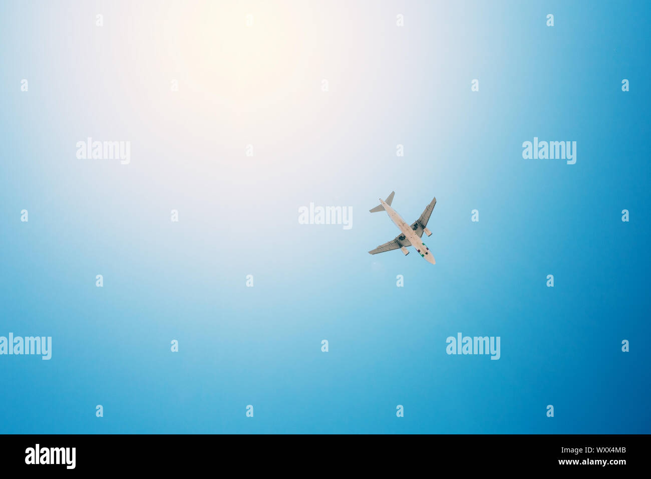 Aeroplano sorvolare i cieli blu e raggi solari. Concetto di viaggio. Foto Stock