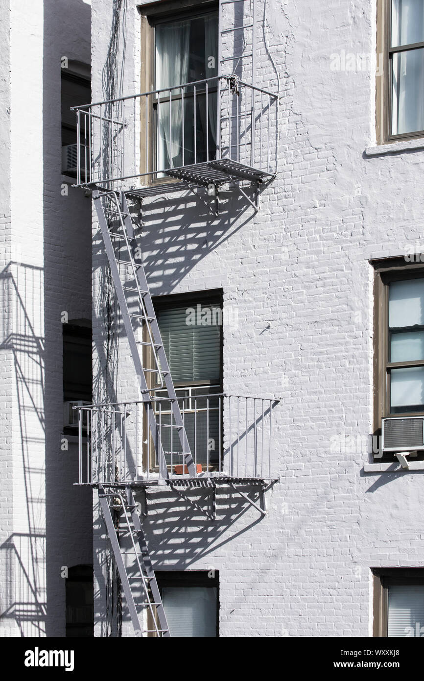 Tradizionale tipica metal fire escape scala sul walk-up appartamento arenaria blocco sul west side di Manhattan, New York City Foto Stock