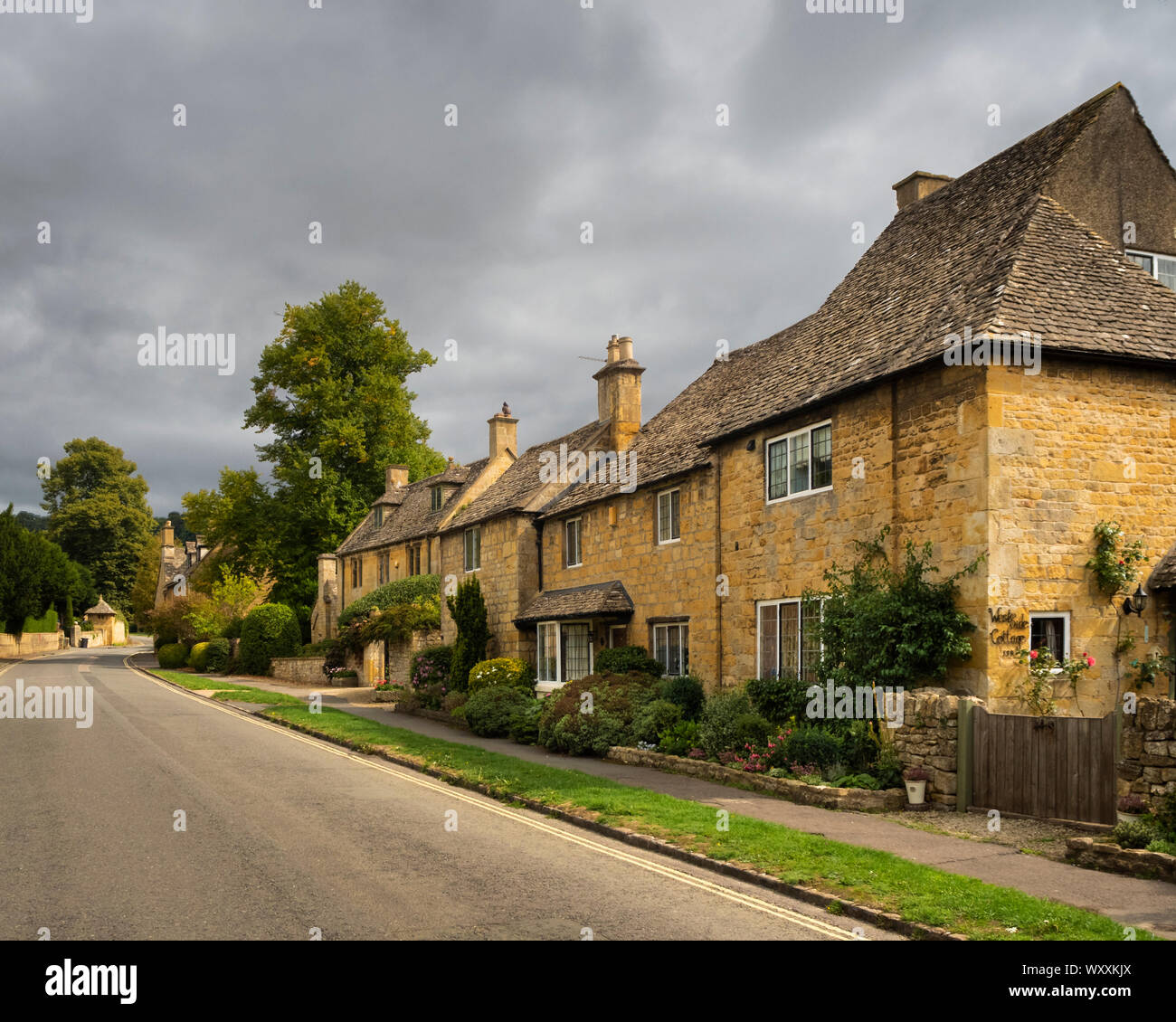 Una fila di case su una strada di Broadway Gloucestershire Inghilterra preso dalla strada in estate. Foto Stock