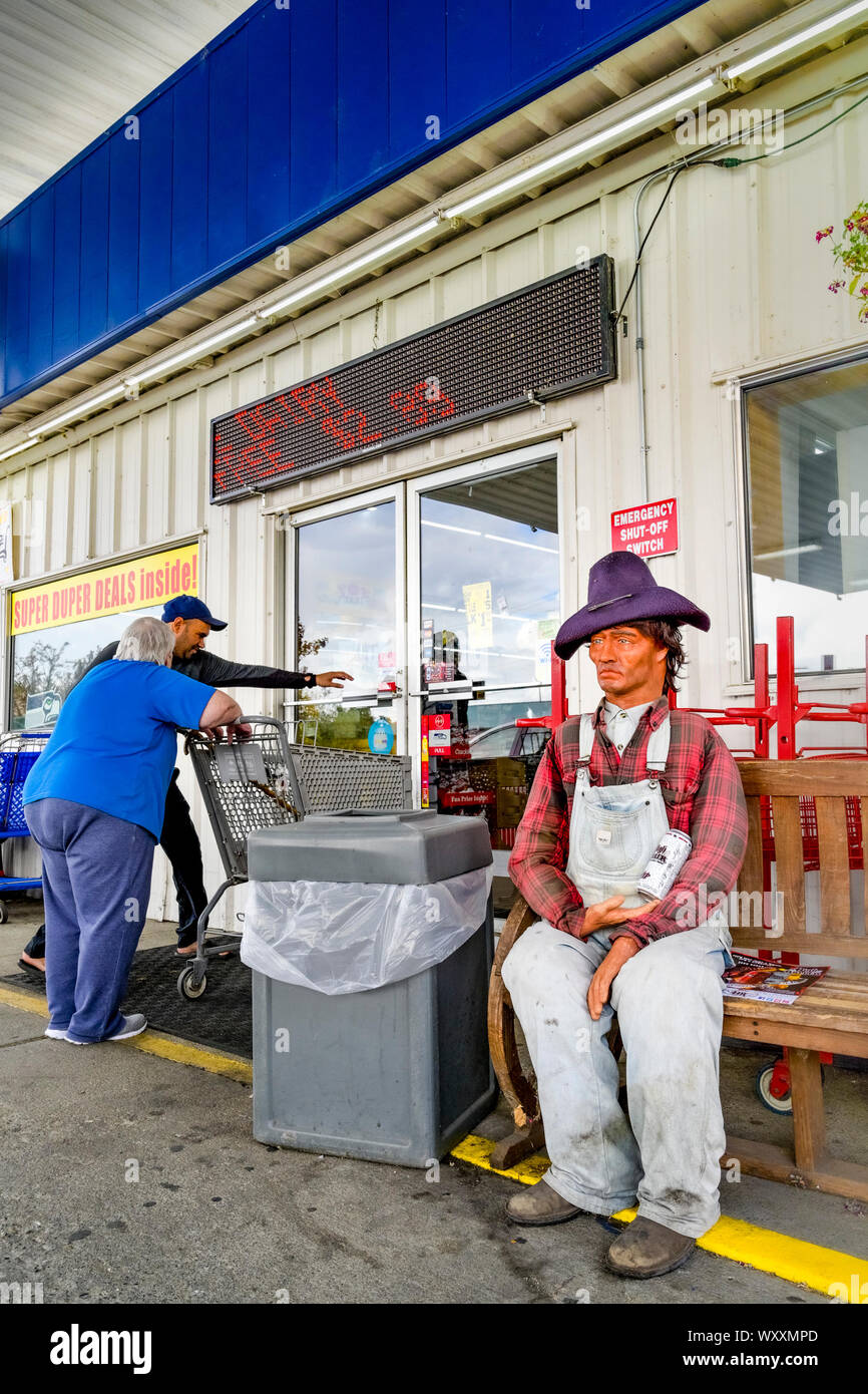 L'uomo porta di apertura per la donna al minimarket, Foto Stock