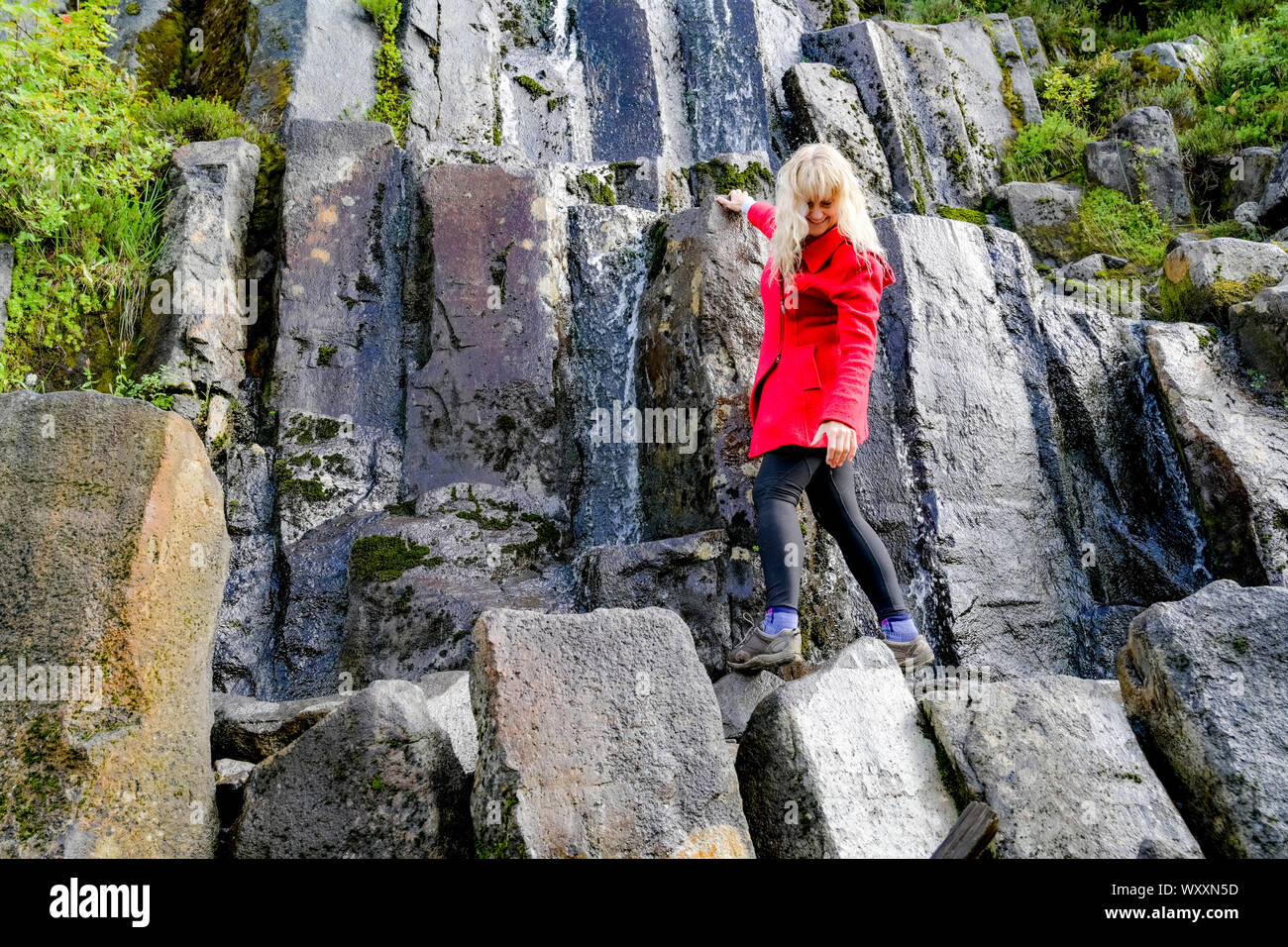 Donna sul sentiero con basalto colonnare rocce, Bagley sentiero dei laghi, , Mount Baker, Washington, Stati Uniti d'America Foto Stock