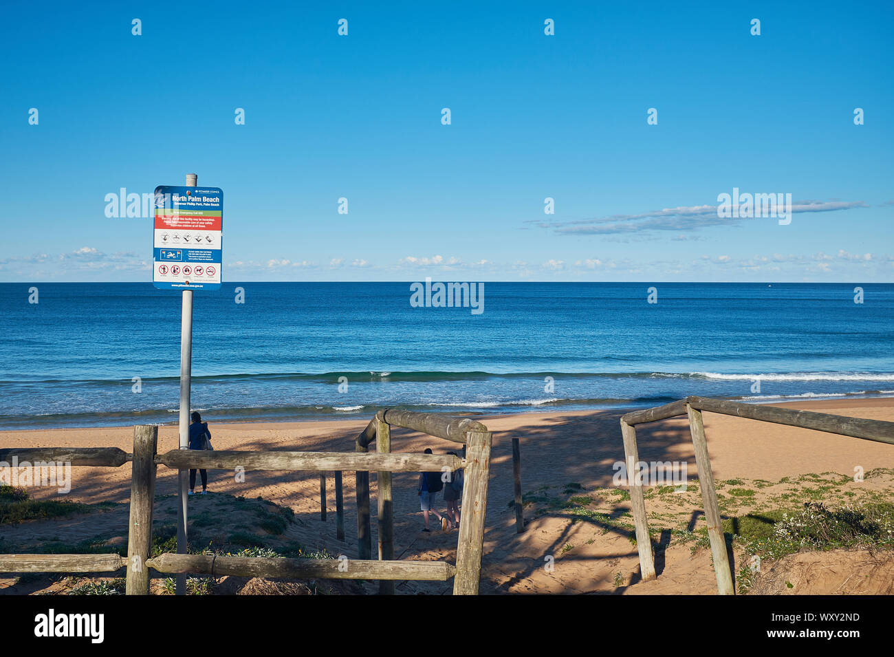 Ingresso a Palm Beach con un cartello di avvertimento in una giornata di sole con un cielo azzurro, Nuovo Galles del Sud, Australia Foto Stock