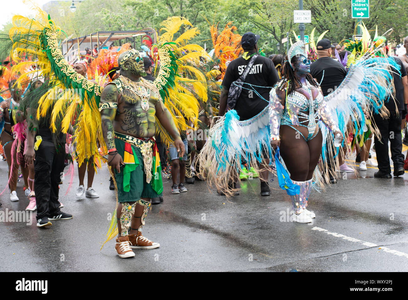Tanzend zu lauter Musik laufen Teilnehmer der West Indian Day Parade di New York City Un den Zuschauern vorbei und animieren diese. Foto Stock