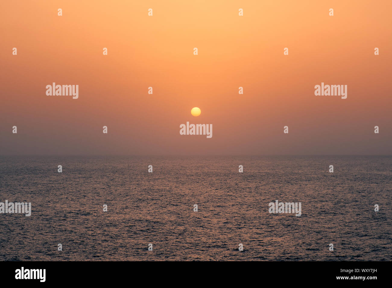 Tramonto sull'acqua, il sole che tramonta dietro oceano - Foto Stock