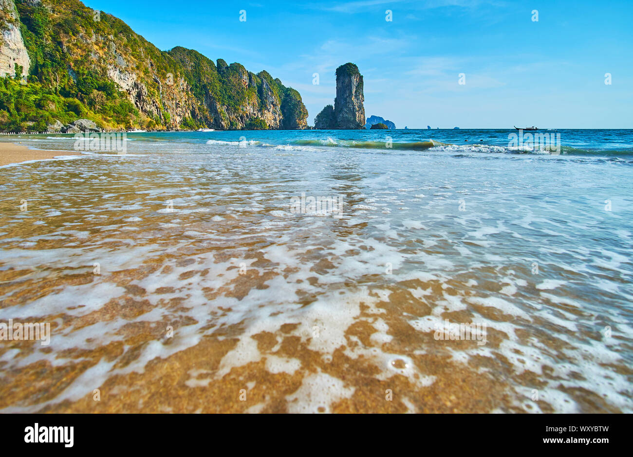 Gustare le dolci onde di marea sulla Spiaggia delle Scimmie con una vista su Ao Nang scenic coast con alte scogliere rocciose, isolotti, giganteschi massi e foreste tropicali, K Foto Stock