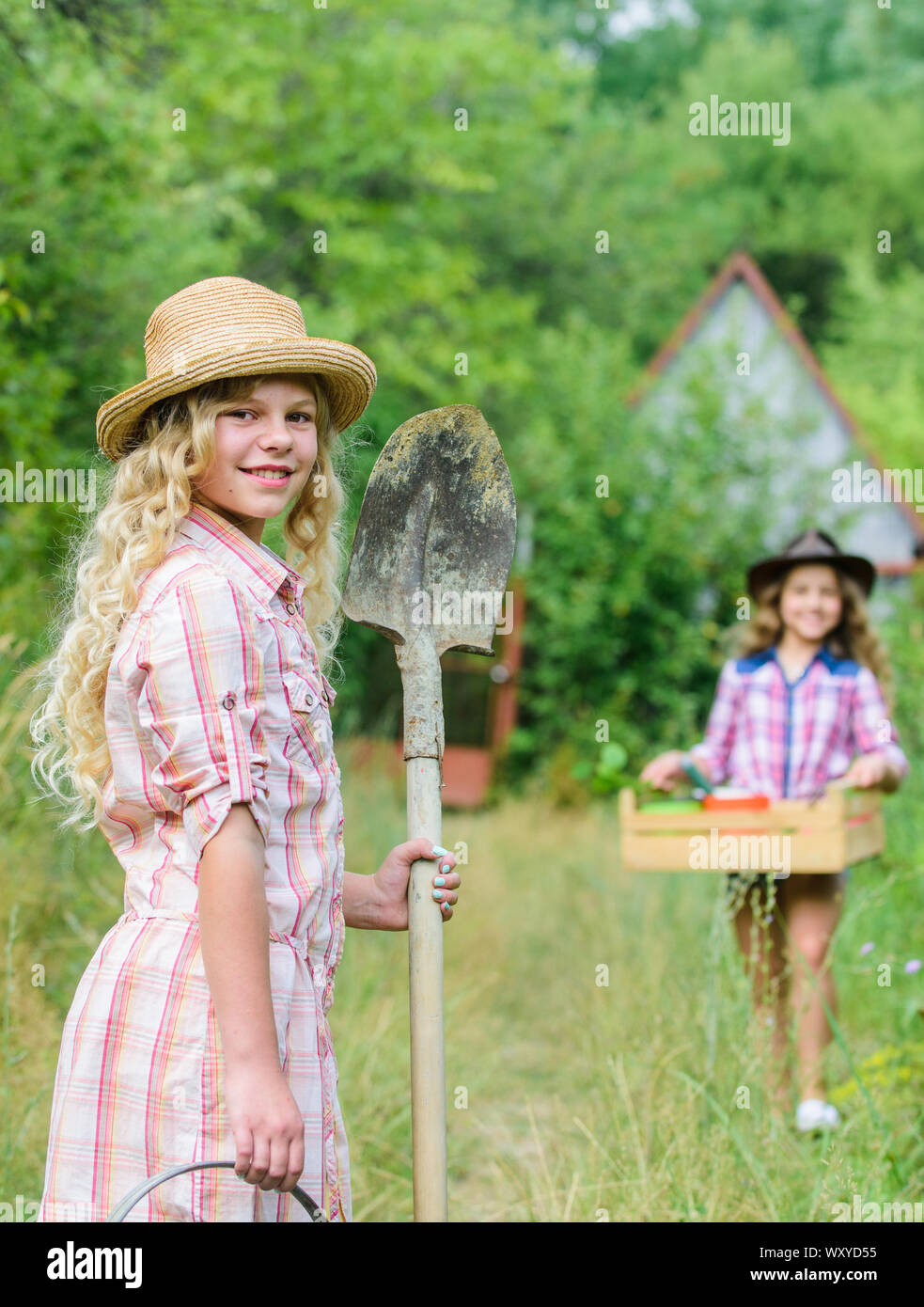 Mi piace lavorare con i fiori per la giornata della terra. estate farm. bambino tenere gli utensili da giardinaggio. piccola ragazza contadino con pala in villaggio. Felice agricoltura. molla lato paese. messa a fuoco selettiva. ecologia e natura. Foto Stock