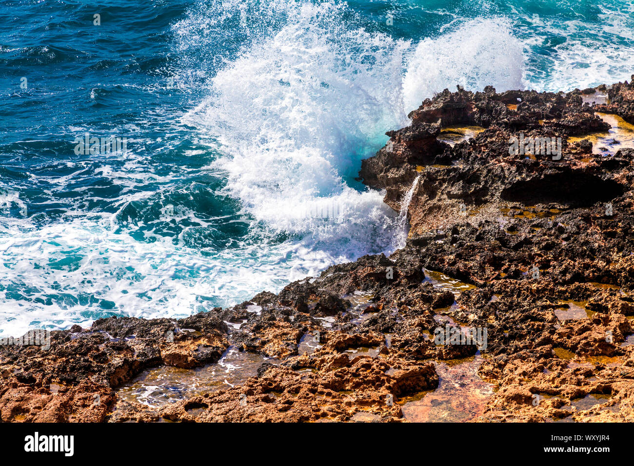 Acqua di mare onde si infrangono contro le rocce in Can Marroig, Formentera, isole Baleari, Spagna Foto Stock