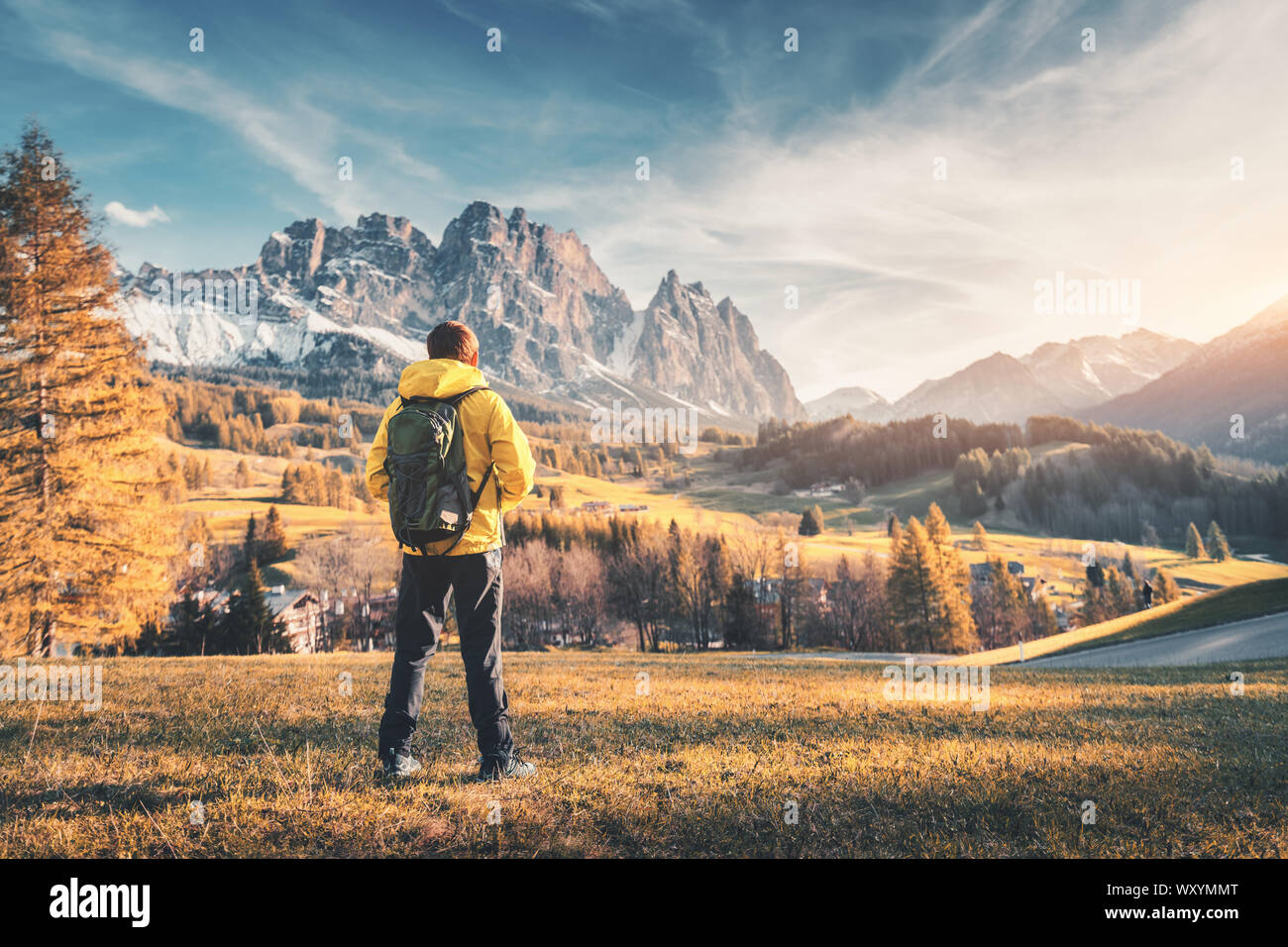 Giovane uomo con zaino e montagne al tramonto Foto Stock