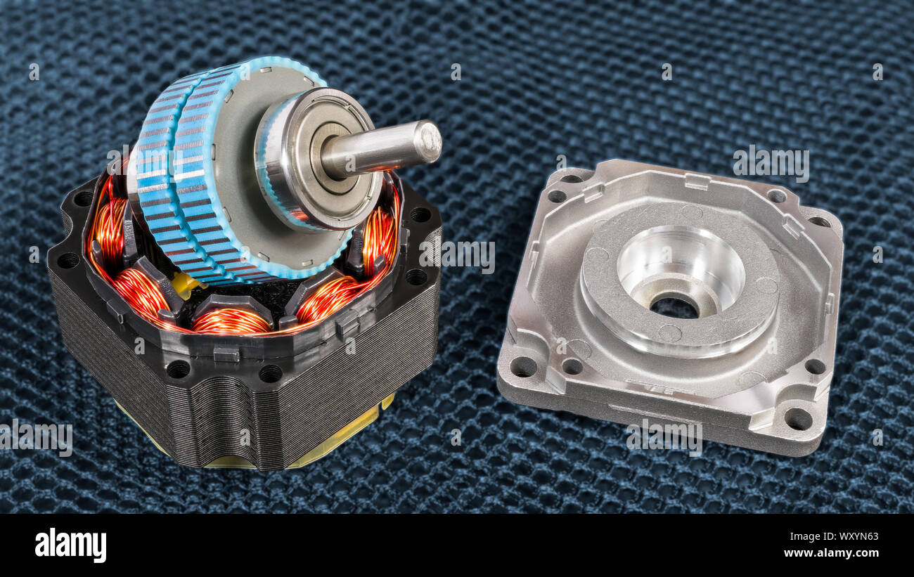 Smontaggio motore elettrico passo-passo le parti su una griglia scuro dello sfondo. Blue rotore con albero in acciaio su Statore nero con induttori e avvolgimenti di fili di rame. Foto Stock