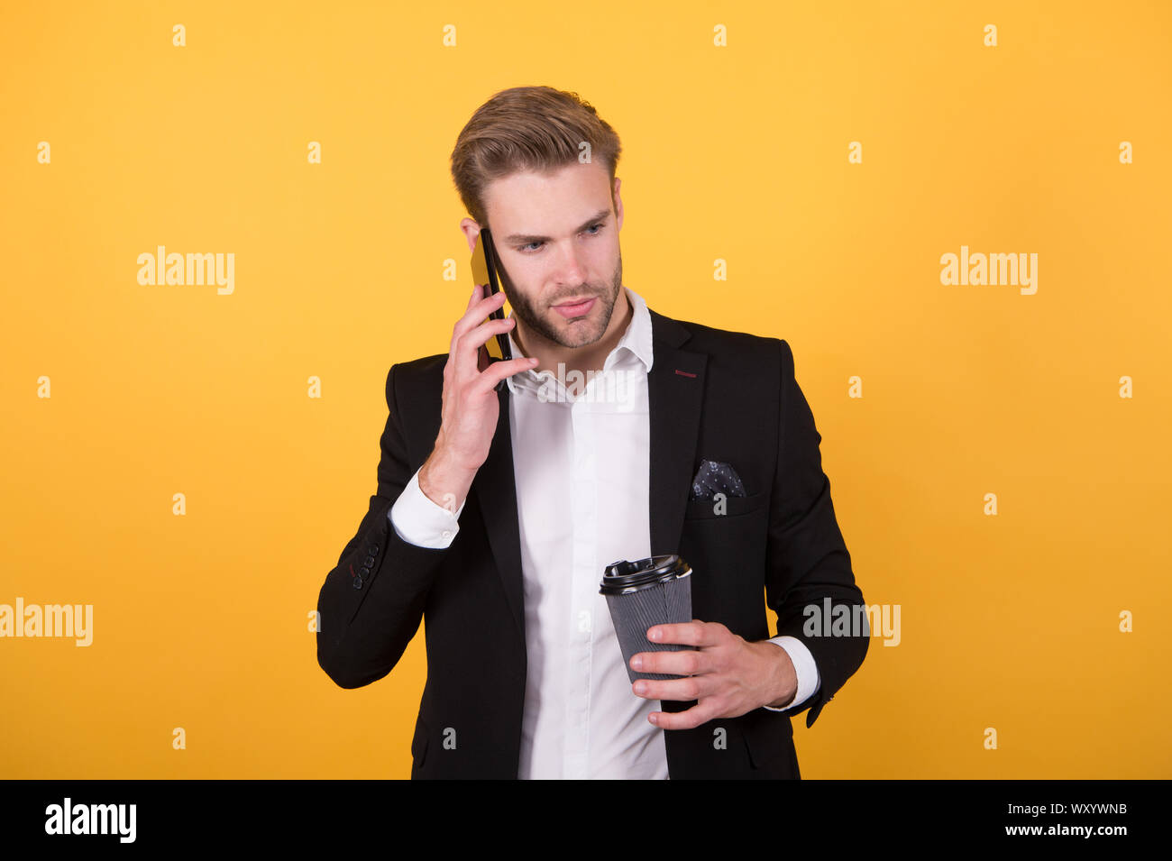 Per le notizie. L'uomo bere il caffè parlare telefono sfondo giallo. Bere il caffè. Motivi gli imprenditori bere il caffè. Pausa caffè concetto. Relax e piacere. Concentrati sulle informazioni di ascolto. Foto Stock