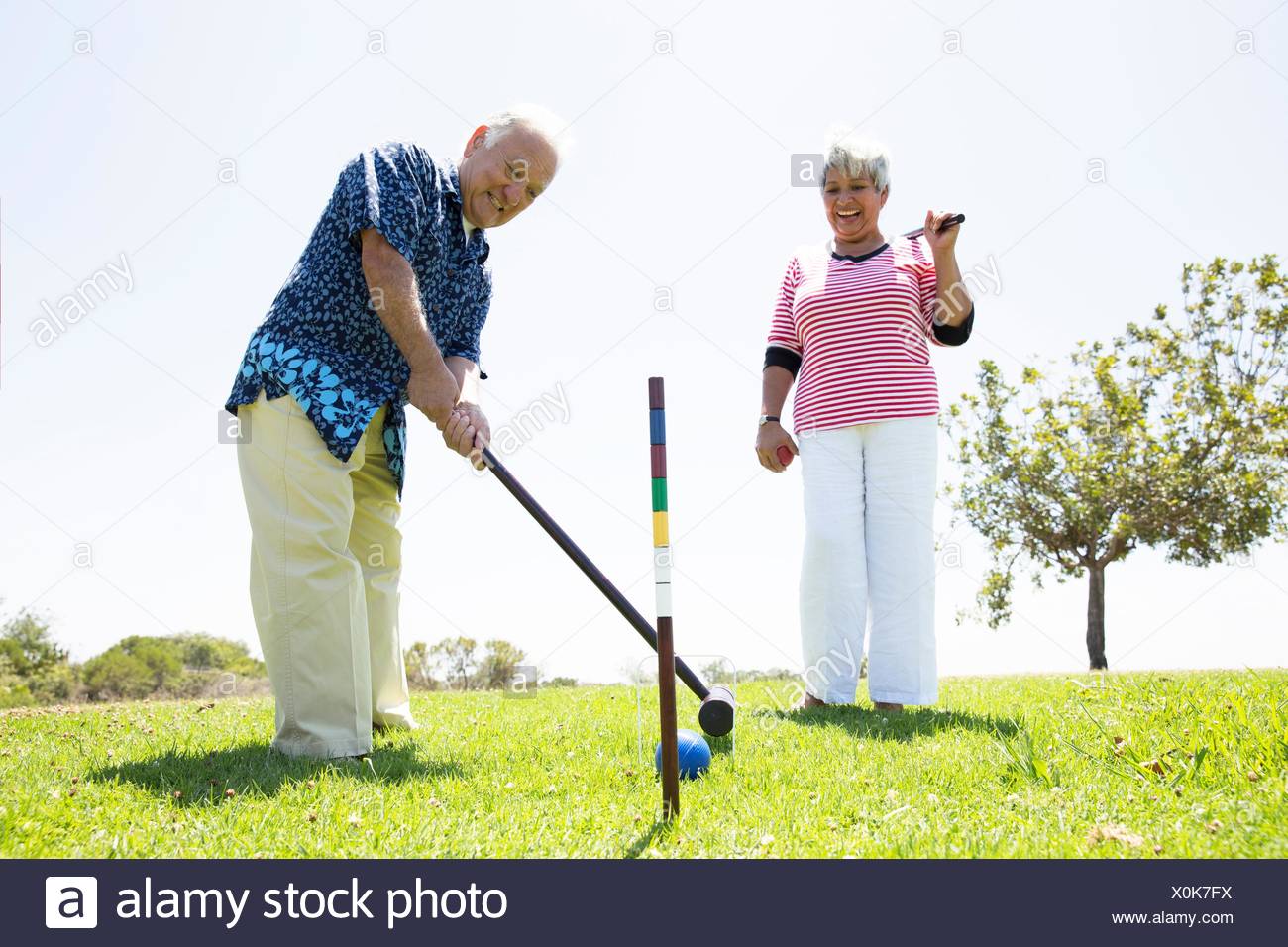 Coppia senior giocando croquet, all'aperto Foto Stock