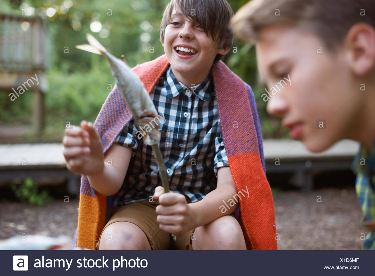 Ragazzo giovane azienda stick con pesce su pronto a barbecue Foto Stock