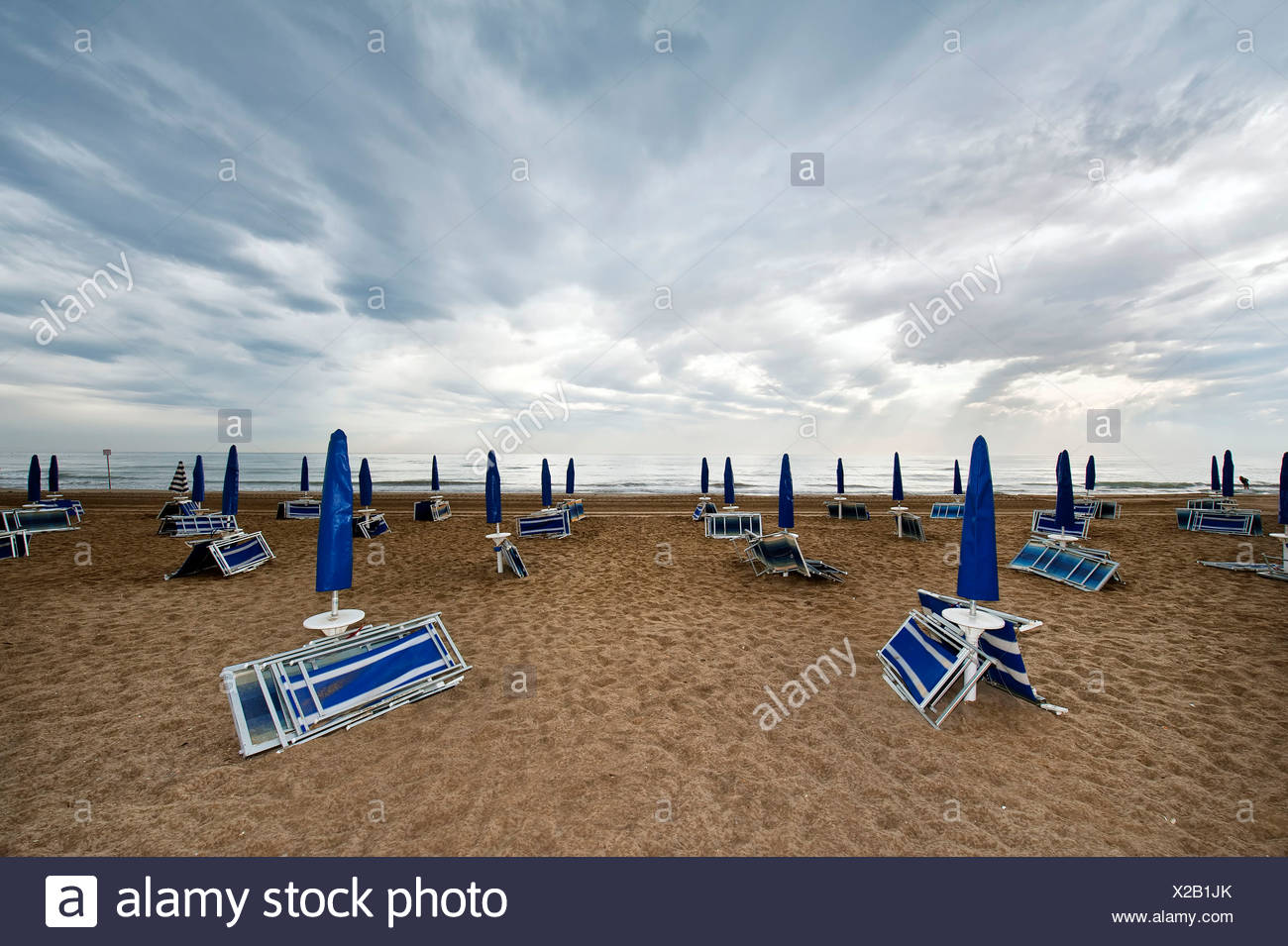 Ripiegata Di Sedie A Sdraio E Ombrelloni Sulla Spiaggia In