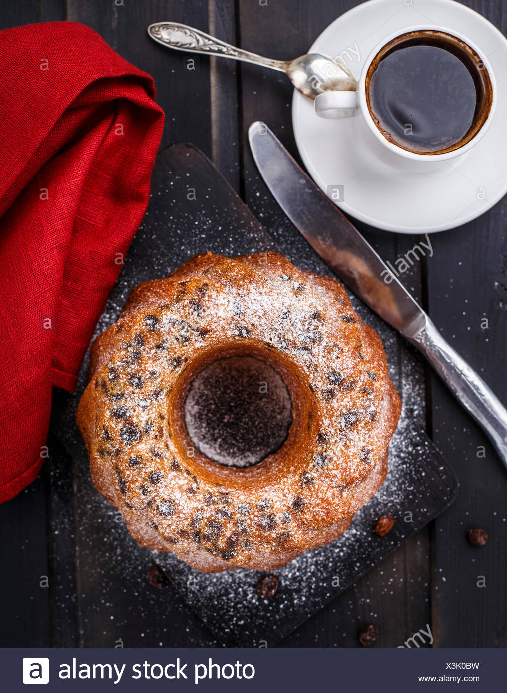 Torta con uva passa su un nero pannello di legno Foto Stock