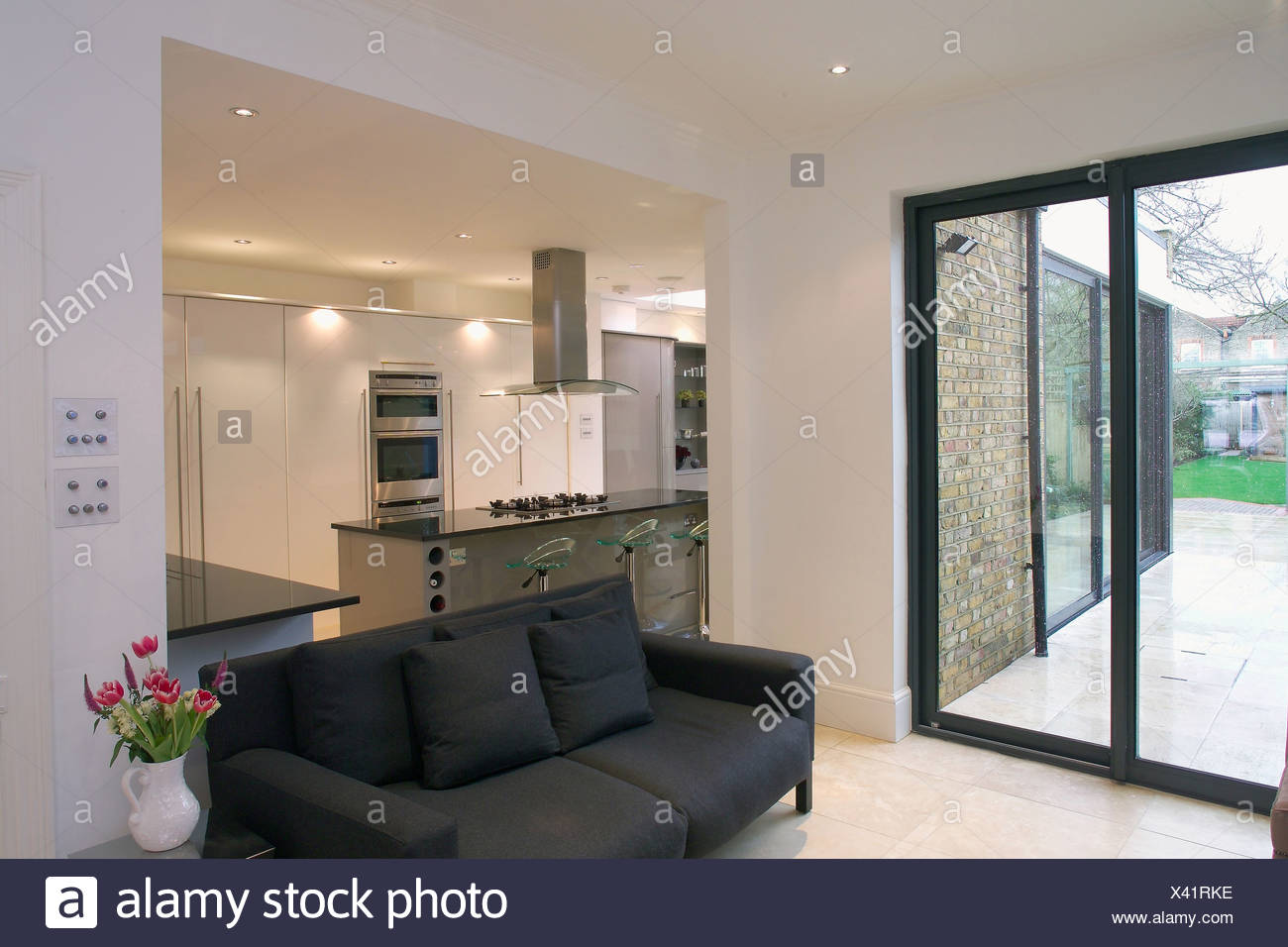 Le porte del patio e divano nero in openplan moderna sala e cucina ... Sala e cucina