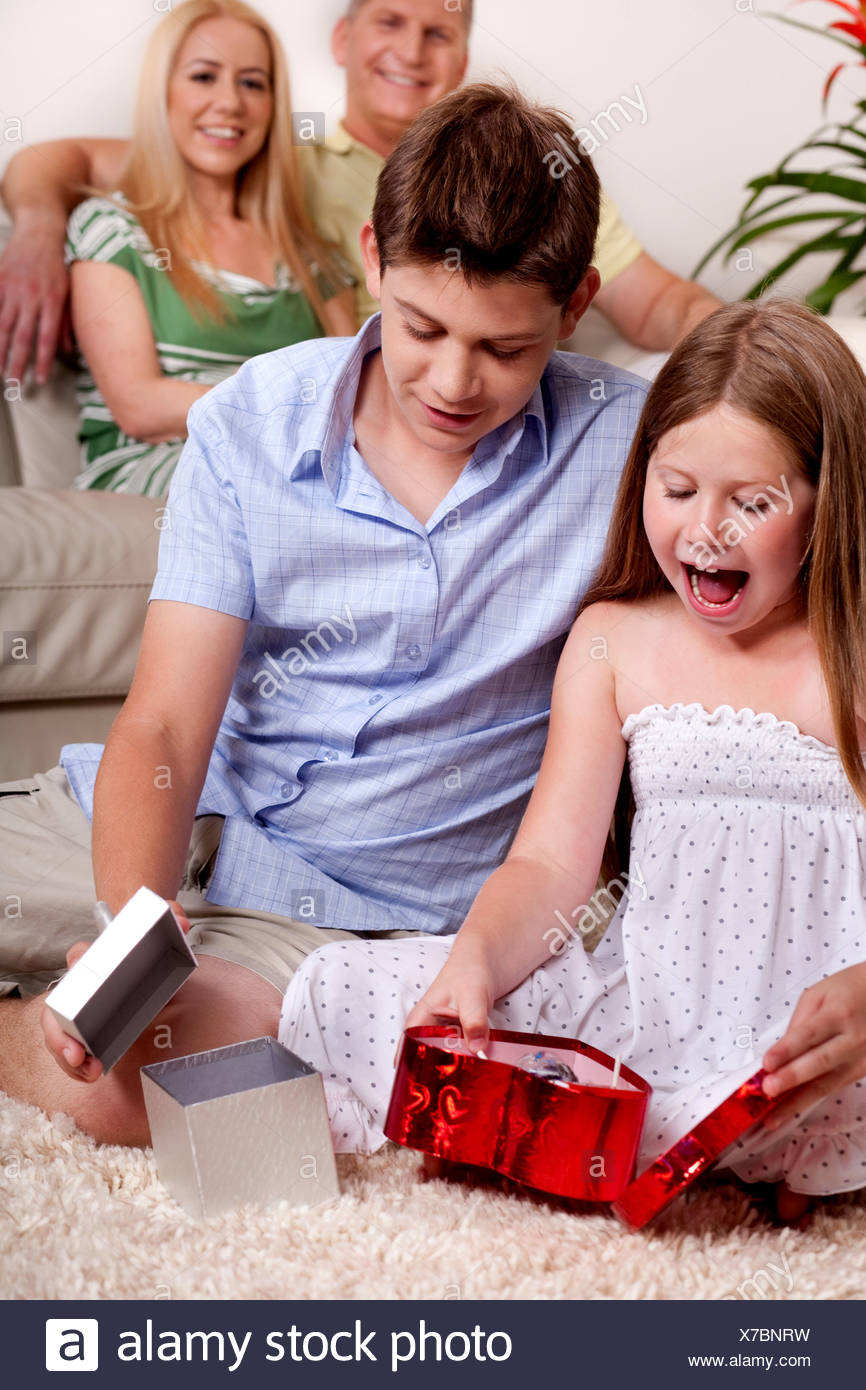 Regali Di Natale Fratello.Fratello E Sorella Occupato In Apertura Di Regali Di Natale Con I Genitori In Background Foto Immagine Stock 279927085 Alamy