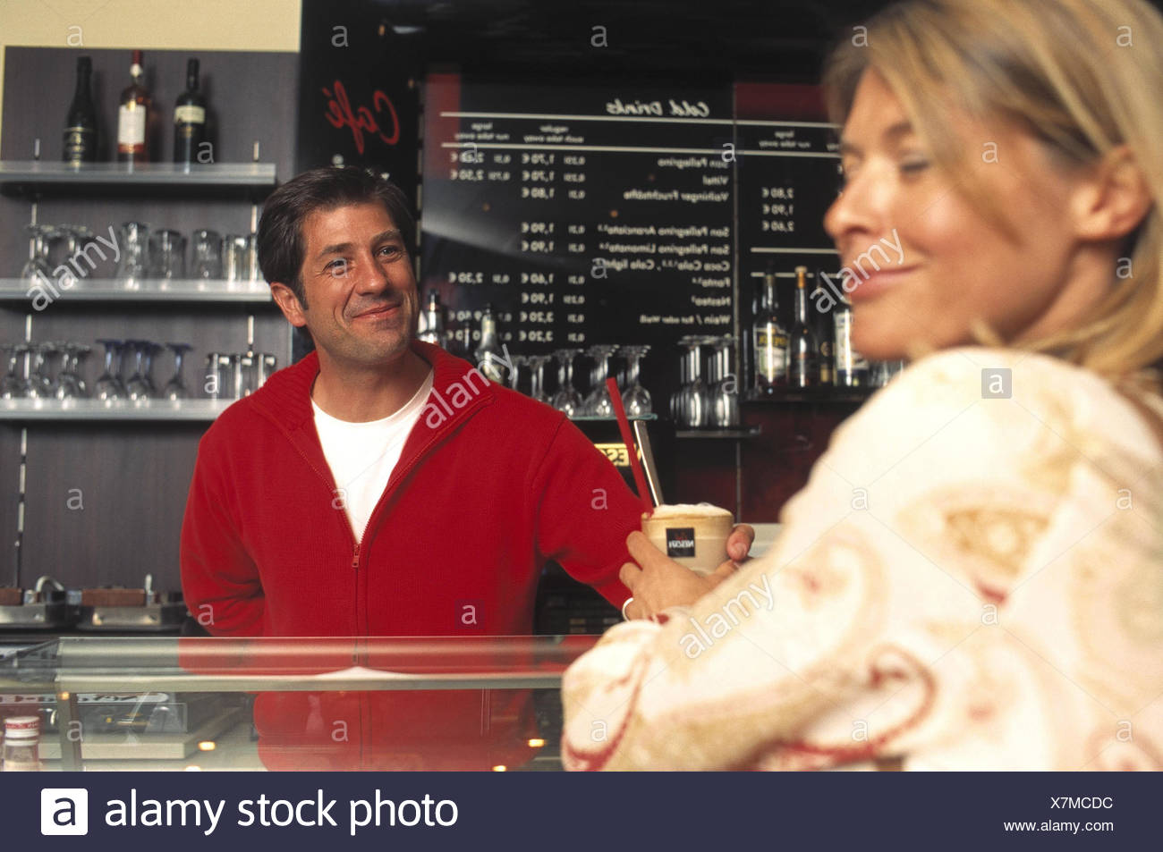 Donna, bar, contatore, Ordine cappuccino, lavoratore di ufficio, flirt, cafe, gelateria, all'interno, l'uomo, cameriere, flirt, sorriso, affetto, caduti, anticipi, fascino, ammiratore, mani, touch, scherzo, tease, scherzo, Latte Macchiato Foto Stock