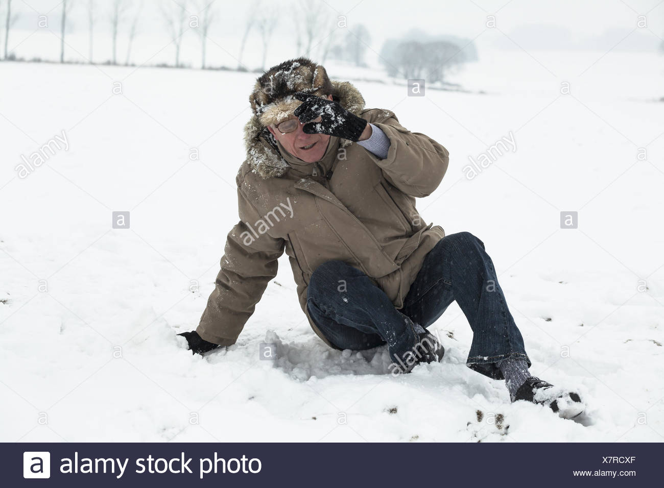Senior uomo incidente cadendo sulla neve in inverno. Foto Stock
