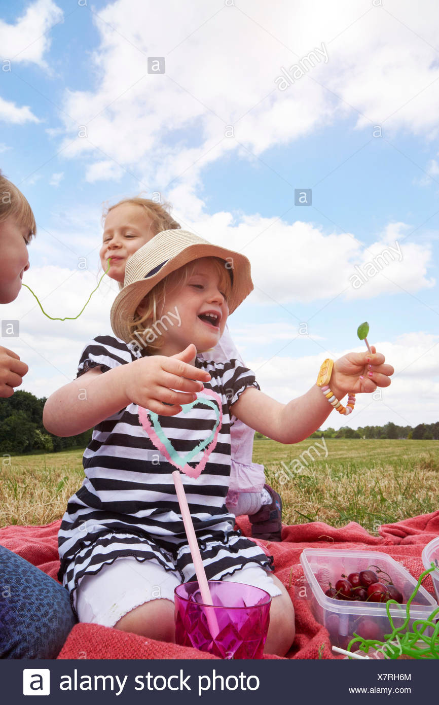 Tre bambine con dolci su un prato Foto Stock