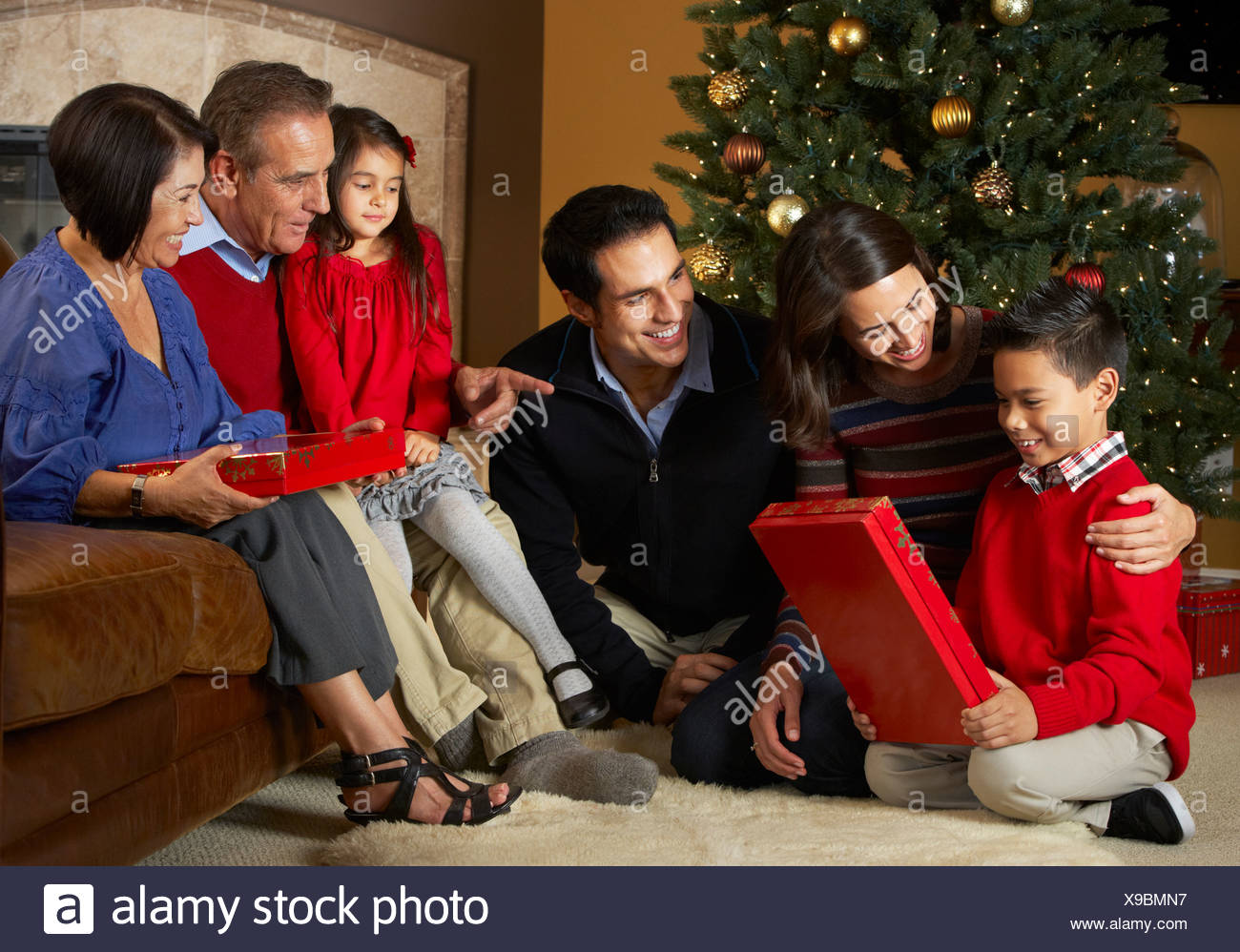 Apertura Regali Di Natale.Multi Generazione Apertura Famiglia Regali Di Natale Nella Parte Anteriore Della Struttura Ad Albero Foto Stock Alamy