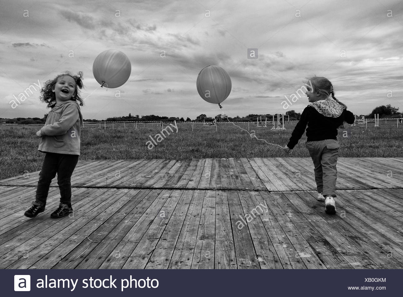 Due ragazze che giocano all'aperto con palloncini Foto Stock