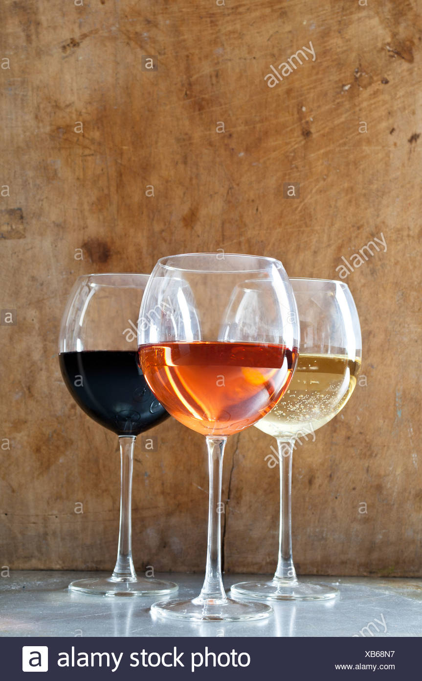 Rose, vini bianchi e rossi in bicchieri Foto Stock